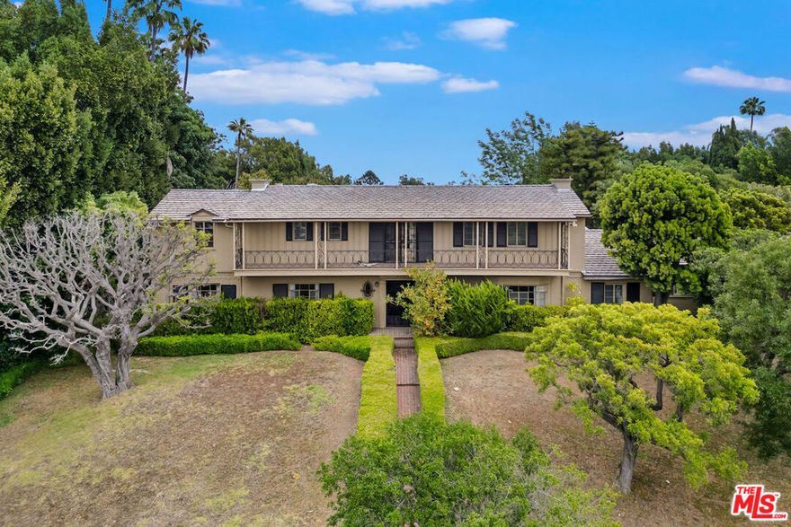 Gated and set majestically back from the street on one of the largest lots in Little Holmby, this classic Monterey Traditional home beckons an architectural purist to restore it to its original glory or an imaginative buyer ready to create the estate property of their dreams. Originally built in 1937, this enchanting and character-filled home retains all the hallmarks of its old-world pedigree, with crown moldings, wainscoting, and hardwood floors throughout, in a style harkening back to the glamour days of early Hollywood. The sublime circular entry with parquet wood flooring, soaring ceiling, and sweeping staircase leads, on one side, to a lavish step-down formal living room with mammoth picture windows and a stately fireplace; and on the other, to a large formal dining room with additional parquet flooring and bay windows. The rear of the house features a gracious family room with a fireplace and a curved bank of windows, a serene breakfast/sitting area with built-in wet bar, and a cook's kitchen with a large pantry and built-in banquette - all opening to the extraordinarily large grounds. The floorplan, with its flow to the outside, offers the perfect space for large formal gatherings or intimate private affairs. In addition, there is a small office space, a maid's bedroom suite off the kitchen, an elegant powder room, and a vintage back staircase. Upstairs are three bedrooms, including two generous family bedrooms with ensuite baths, and an enormous primary suite with dual closets, coved ceiling, and a sumptuous full bath. The house sits on an expansive 36,000+ sq ft lot, boasting a large front motor court with parking for numerous cars, a detached three-car garage with a full guest house above, grassy play areas in front and behind the house, a full-sized tennis court, a lower pool area with dual changing rooms, and breathtaking views across Holmby Hills and beyond. Coupled with its classic and romantic features, the home is mere moments from the relaxing atmosphere of Holmby Park, the world-class shopping at Westfield Century City, the glamour of Beverly Hills, and the cultural offerings of UCLA and Westwood. It also allows access to the prestigious, award-winning Warner Avenue Elementary School. This is a once-in-a-lifetime opportunity to own one of the most expansive estate properties in Little Holmby.