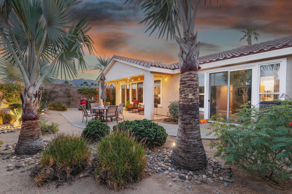 A Suite Deal! Charm and quality are hallmarks of this immaculate and beautifully crafted 1,667 SQ FT Monterey Model with 2-bedrooms, a den or 3rd bedroom, and 2-full baths, located in the highly desired Trilogy Golf Club at La Quinta. Richly upgraded with stunning wide-plank floors in the main living areas, and available fully furnished, with newer A/C, the home offers all the comforts of a fun vacation property coupled with the durability, efficiency, and ease of maintenance of a rental. Experience the splendor of desert living in a home that makes indoor and outdoor living seamless. Outdoors, the towering Santa Rosa Mountains from the front and back patios will have you awestruck, while indoors, the sun as it radiates softly through the big picture windows make the whole home feel airy and cheerful. The kitchen with its extensive counters, cabinets, and pantry offers plenty of space for even the most prolific chefs, while the extra-large center island makes food preparation and entertaining a breeze. Serve up dinners in the dining area or outdoor BBQ on the covered patio. The den offers a soothing and comfortable respite perfect for snuggling up with a movie or good book. The main bedroom suite is spacious with sliding doors that step out to the private back patio. The bath features dual vanities, a linen closet, walk-in shower, and deep walk-in closet. Separated for privacy, friends and family will love the guest bedroom and full bath. A separate laundry room with deep sink and cabinets is steps away from the oversized garage that easily fits up to 2-cars, golf cart, bikes, and athletic equipment. Take in the beauty of the professionally landscaped yard, with custom pavers and richly textured, mature trees and flowering plants. By day, enjoy a cup of Joe on the patio as the sun casts its first shadows as it rises in the east. At nightfall, grab a glass of wine and sit fireside as the landscape spotlights come alive, and the moon makes its magnificent ascent over the valley. Trilogy at La Quinta is a 55+ active adult community of 1,238 homes offering the ultimate in golf and desert resort living.