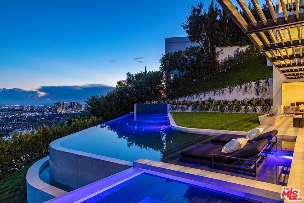 Eclipse Beverly Hills. Triumphant modernism meets Art Deco jewel box to create a most special Eclipse. A culmination of 5+ years of design and construction, this gem encompasses over 10,270 sq. ft. with jetliner views from the city to the ocean. Upon arrival, large gates reveal massive motor court that can accommodate approx. 15 cars and security suite. Descend the most dramatic entrance in the city with a skylit elliptical staircase floating over a waterfall and pond. A Showstopper in every way, the great room offers 14ft ceilings and walls of automated glass that retract to the view. Designed for entertaining with full show kitchen and back catering kitchen. Primary bedroom is the ultimate Deco Fantasy with walls paneled in Macassar and velvet, lavish double baths and closets. Lower level offers a game room and bar, screening room, gym and 3 additional bedroom suites. 92ft long infinity edge pool, curves before a vast lawn and gardens. Eclipse is and will always be a Beverly Hills legend.