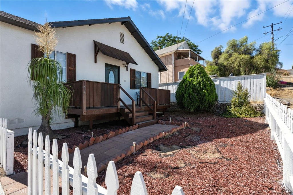 Welcome to this thoughtfully upgraded 3-bedroom, 2-bathroom single-story home nestled in the heart of historic downtown Lake Elsinore. From the moment you step inside, you'll be greeted by an open-concept floorplan drenched in natural light, perfectly designed for comfortable living & the ease of entertaining. The spacious kitchen offers ample storage, a stylish backsplash, a farmhouse-style single bin sink, a portable island, & a hanging pot rack, all seamlessly flowing into the living & dining areas to create an inviting central gathering space. Freshly painted inside & out, this home also features new bathroom flooring & a beautifully tiled walk-in shower within the primary suite. Outdoors, enjoy year-round living on the updated front, back, & side porches or unwind beneath the cozy outdoor gazebos with string lights, ideal for relaxing evenings or hosting guests. Sitting on a large lot with gated RV parking & a massive backyard full of potential, this property offers endless possibilities. The detached garage includes abundant storage cabinets, a built-in workbench, & a brand-new garage door opener for added convenience. Located just minutes from the lake & within walking distance to Main Street's shops, dining, & local events, this move-in ready gem offers the perfect balance of charm, lifestyle, & location. Don’t miss your chance to make this beautiful home yours!