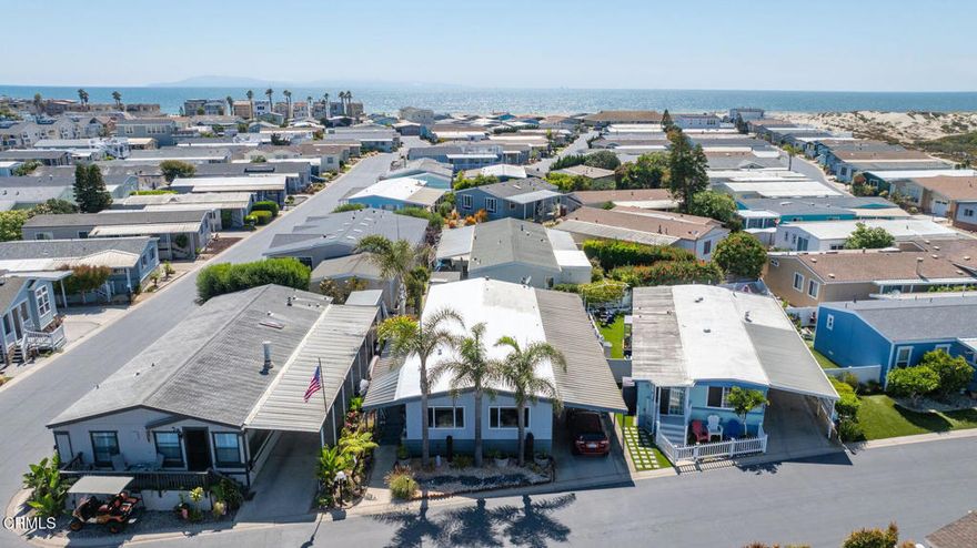 Live at the Beach! Just a short walk to the shoreline, this 2 bedroom, 2 bath beach home is not just a residence- it's a lifestyle! Graced by three mature palm trees, step inside this tropical residence aesthetically inspired by the colors and natural elements of the coast. Large windows invite warmth and natural light into the main living area, a soothing place to relax after a day at the beach, which naturally blends into the dining area and open concept kitchen- complete with granite countertops, newer backslash, updated cabinetry, stainless appliances, and of course the center island- guaranteed to be the central hosting spot for family & friends! Down the hall is the large den, convenient indoor laundry room with exterior access, upgraded guest bathroom, and large primary bedroom w/ walk-in closet and ensuite bath featuring a walk-in shower and separate soaking tub.  Outside, the home offers a relaxing porch, landscaped side and back yard with room for gardening, PLUS a fully enclosed large storage room- great for surfboards, bikes, additional storage or even an art studio/hobby room! Located within the quiet & privately gated Oxnard Mobile Home Park, this homes enjoys wonderful neighbors, affordable space rent, and abundant community amenities including a heated pool & spa, shuffle board, clubhouse w/ full kitchen, gym, and billiard room.  All this and just minutes to the Channel Islands Marina, fabulous restaurants, shopping, bike paths, trails, and parks.