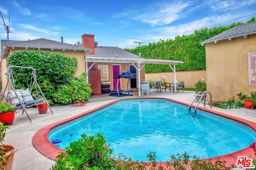 Tucked behind tall privacy hedges and surrounded by lush landscaping, sits a charming single-story home in the heart of Valley Village-- one of LA's most desirable and walkable neighborhoods. This well-maintained home offers a thoughtfully designed floor plan featuring a bright living room, cozy family room with fireplace, formal dining area, and a classic galley kitchen with side rose garden views. Three bedrooms with plenty of storage space, a bathroom with standing shower, and a larger bathroom with tub and shower complete a comfortable and very usable space. Natural light, original hardwood floors and fixtures add to the home's inviting character. The curb appeal is undeniable with a large front lawn, expansive rose gardens, and citrus trees. Step into the private backyard, where a sparkling pool and patio area await, ideal for BBQs, weekend relaxation, and gatherings.  A detached garage offers potential for an ADU, home office, or creative space, providing future flexibility and value. With easy walkability to local shops, restaurants, and houses of worship, plus close proximity to major freeways, this home combines privacy, comfort, and unbeatable convenience in a sought-after neighborhood.