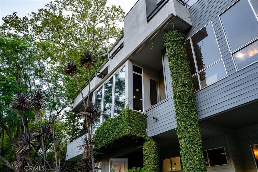 Nestled on an expanded hillside lot in the heart of Bel Air, this contemporary home offers amazing canyon views, timeless style and nearly 4,000 sqft of living space. 
The lovely curb appeal includes stone paver walkways, hardscaping, English ivy and beautiful garden beds. Step through the double front door to find rich hardwood floors, high ceilings and large windows that fill the home with natural light. 
The gorgeous kitchen features quartzite countertops, sleek European cabinetry and pro-style appliances. The kitchen leads out to the wrap-around stone patio, complete with an outdoor kitchen, a fireplace, a pergola and plenty of space to dine & entertain. 
The property continues up the hillside, with terraced sections that include a basketball court, a covered pavilion and a stairway that leads to spectacular views at the top. 
Back inside, the primary bedroom includes a beautiful custom walk-in closet, and the spa-like ensuite boasts double sinks, a frameless glass shower and a soaking tub with a view. 
One of the guest rooms also has a private ensuite, while another includes built-in bunks with room for four beds. The remaining bathrooms are updated and stylish. Still need more space? Head down to the lower level, which offers a massive rec room/home gym with LVP floors. Don’t forget about the 3-bay garage (one has been turned into a bonus speakeasy) as well as the home’s numerous balconies & fireplaces. 
This hillside retreat in Bel Air is located just a short drive from Westwood, Brentwood, Sunset and the 405. The property is zoned to excellent schools, with the coveted Roscomare Rd Elementary only about a mile away. This home offers the ultimate California lifestyle -- as there are hiking trails, golf courses, the Pacific Ocean and world-class shopping & dining options only minutes from your front door. Come take a tour of this one-of-a-kind property before someone else does!