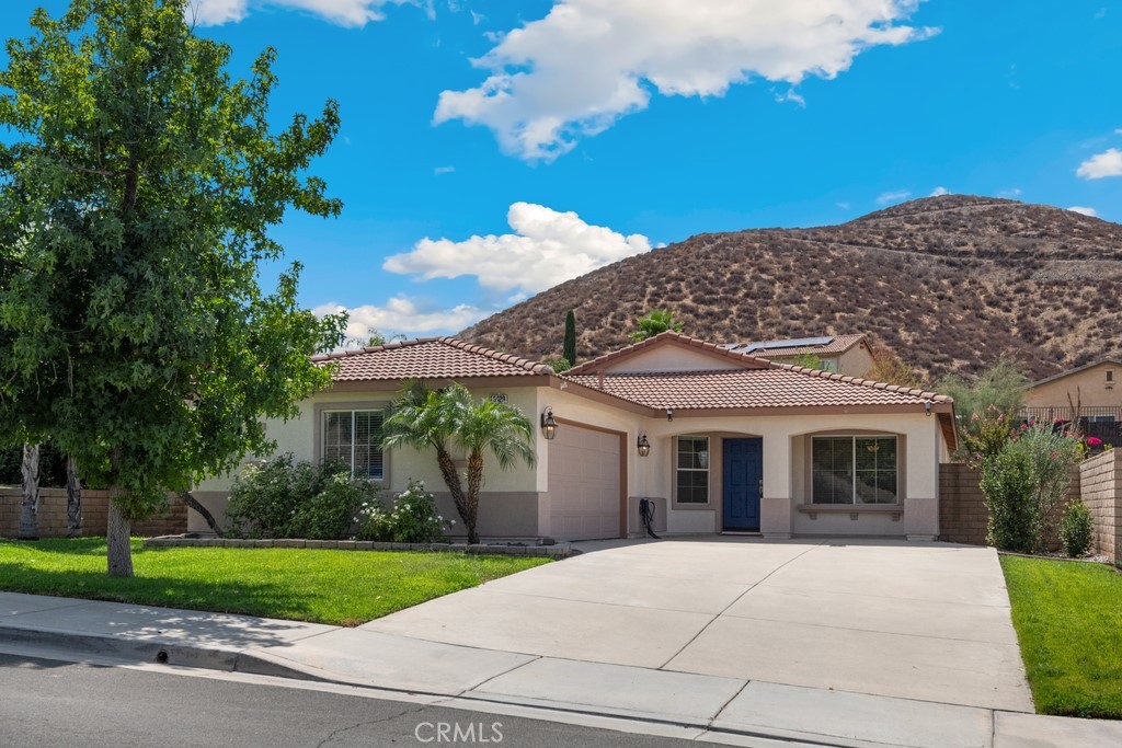 Welcome to this charming 3 bed, 2 bath home offering 1,617 sq. ft. of living space on a generous 9,583 sq. ft. lot in the highly desirable Canyon Heights community of Menifee. This home stands out with PAID OFF SOLAR, a newly painted exterior, and excellent curb appeal featuring manicured landscaping and a large driveway with plenty of parking. Inside, you’ll find a bright and inviting floorplan with wood flooring, upgraded carpet, fresh paint, and ceiling fans in every room. The spacious living and formal dining area flows seamlessly into the family room with a cozy fireplace. The kitchen offers white cabinetry, tile countertops, and direct connection to the family room for easy entertaining. This home has been thoughtfully upgraded for comfort and peace of mind, including a new American Standard heating and A/C system (17.1 SEER2) installed in July, a roof inspection and repairs completed in June, and a drip irrigation system in the backyard installed in July—perfect for maintaining your outdoor oasis with ease. Go outside to a large backyard with a patio cover and ceiling fans, ideal for relaxing, dining, and hosting gatherings. Located in a small, well-maintained neighborhood of only 394 homes, with an elementary school about a 1/2 mile away. Low HOA, low taxes, and a prime Menifee location close to schools, shopping, and dining make this a must-see!
