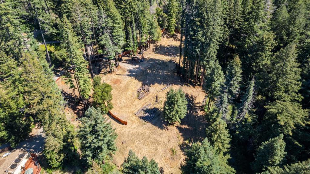 Ready-to-Build Dream Property with Approved Plans and Utilities in place. Skip the hassle of permitting - this is a rare opportunity with approved plans for a 3,004 sqft two-story home plus a 1,197 sqft ADU, all set on over 4 private, sun-drenched acres. Key improvements already in place: PG&E electric service (200-amp main panel + 100-amp subpanel) Big Basin Water Co. water service Working septic system with concrete tank High-speed internet Well-paved access road The planned main residence includes 2,764 sqft on the entry level, 240 sqft lower level, and terraced patios with sweeping views. Want to make plan modifications? That is an option. Plus, with existing utilities and permits, you may be eligible to live onsite in a trailer or tiny home during construction with a simple application to the County. There are two existing RV sites with 50 amp electrical service already installeda major advantage. Explore the northern edge of the property, where you will find a shady grove of redwoods and a seasonal babbling brook. Located just minutes from Boulder Creek Country Club and downtown Boulder Creek, this peaceful location offers easy access to both Santa Cruz and Silicon Valley. This is a rare, ready-to-go building opportunity bring your vision to life without delay.