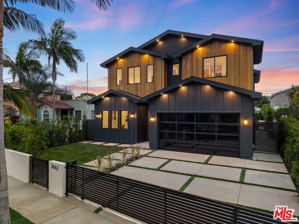 Newly built with timeless farmhouse character and modern refinement, this Mar Vista residence offers a thoughtful floor plan and beautifully layered design. A mix of warm wood tones, natural stone, and expansive glass creates interiors that feel both inviting and elevated. Soaring ceilings and abundant light enhance the open concept living and dining areas, designed for seamless flow to the outdoors. At the center of the home, the chef's kitchen makes a striking impression with custom-paneled appliances, rift white oak cabinetry, and a dramatic Taj Mahal quartzite waterfall island. The main level also includes a private en-suite bedroom, ideal for guests or a home office. Upstairs, the primary suite serves as a private retreat with its own fireplace, balcony, spa-inspired bath with soaking tub, rain shower, dual vanities, and a spacious walk-in closet. Two additional upstairs suites offer comfort and privacy, each finished with refined details and abundant storage. The backyard is designed for entertaining with a built-in BBQ, lush landscaping, and generous space for gathering. Nestled on a quiet street in one of Mar Vista's most sought-after pockets, this modern farmhouse delivers sophisticated design, flexible living, and enduring style.