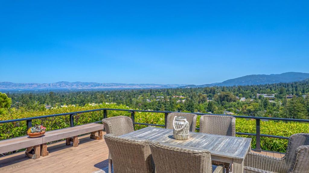Absolutely stunning Saratoga home with breathtaking panoramic views of downtown and Silicon Valley. From the moment you enter, you're welcomed by soaring vaulted ceilings and gleaming hardwood floors that lead seamlessly to an expansive outdoor deck overlooking the hills. Spacious living room/dining room with fireplace and a wall of windows to soak in the view. The beautifully updated kitchen features granite countertops, solid wood cabinetry, and ample workspace, ideal for the discerning chef who enjoys cooking with a view. Large kitchen island with wraparound seating. Secondary seating area provides flexible use, whether as a small family room, reading nook, or casual entertaining space. Enjoy the serenity of a beautiful sunrise from your main bedroom and access to your own private deck, generous closets, and an elegantly updated en-suite bathroom. Two additional bedrooms offer flexible living options as a guest room or office. Separate laundry room. Large 2 car garage includes built-in shelving and a dedicated workspace perfect for any hobbyist or handyman. Located just minutes from charming downtown Saratoga, this stunning home is close to top-rated schools, world-class dining, shopping, and freeways all while offering peace, privacy, and the best of Saratoga living.