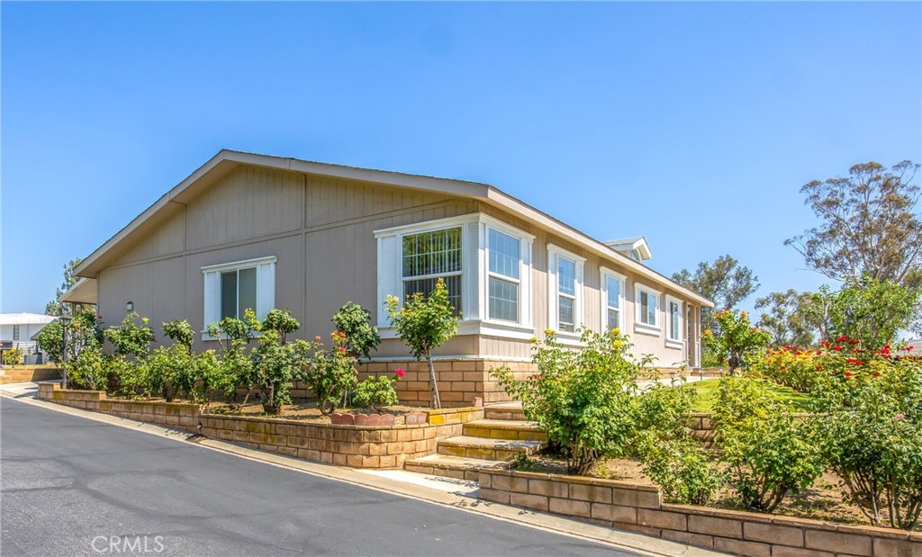 Nestled at the base of the scenic mountains in one of the most highly desired 55+ communities in the Inland Empire, this spacious 3-bedroom, 2-bathroom home offers both comfort and breathtaking views. The master suite includes a private office—perfect for working from home or relaxing in a quiet retreat. Enjoy your morning coffee from the inviting front porch overlooking the valley, or unwind surrounded by the vibrant colors of multiple rose bushes that beautifully accent the home's exterior. Inside, you’ll find a large kitchen with a cozy breakfast nook, a dedicated laundry room, and a thoughtfully designed layout ideal for both everyday living and entertaining. The spacious living room features a fireplace and picturesque views of the valley, creating a warm and inviting atmosphere. The oversized carport offers ample space for multiple vehicles, providing both convenience and protection from the elements. The expansive yard provides plenty of space for gardening, relaxing, or enjoying the mountain air. Don’t miss this rare opportunity to own a home in a premier location with unmatched views and serene surroundings.