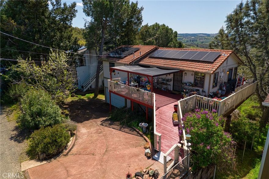 This 3 bed / 2 bath home is a rare opportunity to enjoy Lake County living at a super affordable price. Expansive back windows showcase panoramic views of rolling hills, vineyards, and mountains, while the front porch captures peek-a-boo views of the lake. The two-story design offers exceptional privacy with the primary suite encompassing the entire lower level. A versatile bonus room off the backyard is perfect for an office, gym, or studio, and the two-car garage with laundry adds convenience. Tucked away at the end of a quiet cul-de-sac, the setting is peaceful and private, with deer and wild turkeys often passing through.