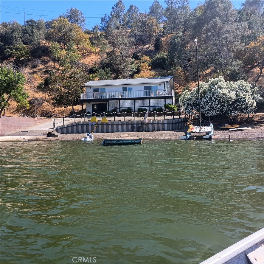 " Lakefront Grotto"......Located in the Quiet ~ Sheltered ~ "Original" Paradise Cove! With a "rare" Gently Sloping Sandy!!! Beach !!!~ Possibly Only 3 coves like this in the entire lake basin! ~ This is a one of a kind home. Not fancy nor glitzy, just Comfortable! ~ Panoramic lake views from every room ~ Great big Flagstone fireplace to keep you warm on those cool winter days listening to the crackling fire ~ The home has been remodeled with new Thermal windows, Window coverings, Pergo Laminate floors, New air conditioning & Heating, Paint, Refiigerator, Water system, Gutters, etc.~ This is a concrete block home so Fire resistant - Rot/termite resistant ~ Easy maintenance! ~ Huge closets! ~ Home inspection report, Pest report, Septic report all clean, reports avaliable! ~ More than ample parking / boat storage @ the front & rear of the home & possibily? put a small travel trailer in the back for the kids to sleep Or~ Potential to build a double wide garage in the rear of the home & add a +- "20x20 Master Lakeview Bedroom" + bath above the garage ~ Presently there is a Single garage under the home with more than ample boat storage or miscellaneous lake toys/Jet skis & laundry appliances. Also wired for installation of a boat winch to pull your boat up the boat ramp in the winter season. ~ "The boat float/ pier @ the lakeside is free floating so no big expensive pier to deal with or maintenance! & lake fees" ~ There are 3 Floating boat systems in the cove to attest for the calm waters here. ~ The owner has lived in this cove for 47 years & can attest to the benefits of this location!~~ In Summation...Lake county is a "Hidden Jewel" Where in California can you buy a LAKEFRONT property @ an affordable cost to working class people? No where! I would venture to say that in 10 years these lakefront properties will be Double ++ in price....There are many "land" parcels & and homes for sale ...... But a home on a Natural Lake?????......" Owner financing" is avaliable with rates "below" bank rates and No loan fees! Negotiable down payment & approval of credit "