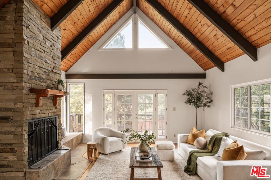 Nestled in the heart of Topanga, this enchanting treehouse-style Traditional home offers a serene and whimsical retreat in the heart of one of Los Angeles' most inspiring enclaves. Step inside and find a harmonious blend of rustic charm and modern comforts, with unique finishes and handcrafted details that infuse every room with character. Perfect for a creative soul looking for a separate studio, home office, or guest house, or a Buyer looking for an investment opportunity to rent the primary residence and/or well-appointed guest house, this provides various options for living in this idyllic community. With soaring vaulted ceilings and stunning architectural elements throughout, the home boasts an airy, open atmosphere that perfectly complements the lush natural surroundings. Expansive windows fill the home with an abundance of natural light and provide breathtaking views of towering trees, vibrant grounds, and mature fruit trees that encapsulate the property. The open living spaces flow seamlessly - ideal for both cozy family gatherings and entertaining on all scales. Relax and unwind in the living room, complete with a dramatic stone fireplace and French doors that open to a balcony. A large dining room features a charming seating area/den, and walls of glass that open to an expansive rear deck that leads seamlessly into the gardens below. The kitchen is well-appointed and offers custom cabinetry and professional-grade appliances - ideal for an intimate dinner or hosting events on all scales. 3 bedrooms complete the main residence, while the lower-level guest house comes with its own kitchen, open living and dining area, bedroom, and additional space currently utilized as a gym. The exterior grounds make this property a true oasis complete with an expansive turf lawn that features various sitting and entertaining areas in the shade of mature oak trees. Lose yourself in the serene walking paths and various "moments" that feature a multitude of locations to take in this coveted natural ambiance. A variety of terraces provide space to relax and unwind and enjoy various luxuries that include a hot tub, swim spa, and firepit. This tranquil setting offers the perfect balance of privacy and connection to nature with walkable access to charming local spots for breakfast and brunch, and two beautiful hiking trails just minutes away. All this, just moments from the vibrant energy of Topanga Canyon.