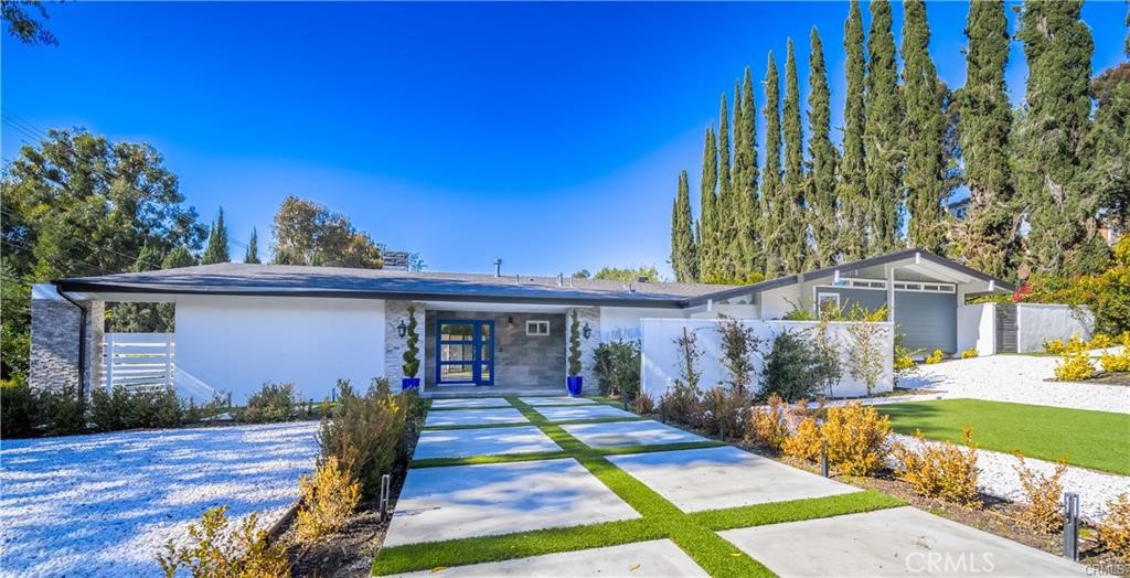 Located South of the Boulevard in one of Woodland Hills’ most desirable neighborhoods, this 4-bedroom, 3.5-bathroom residence was completely renovated a few years ago with exceptional attention to detail. The home features vaulted ceilings, recessed lighting, LVT flooring, new copper plumbing, and a newer roof. The gourmet kitchen is equipped with quartz countertops, a mirrored backsplash, and a ZLINE 6-burner range and hood, opening seamlessly to the living and dining areas. The living room highlights a two-sided marble stacked stone fireplace and connects to a private outdoor sitting area. Retreat to the primary suite, featuring vaulted ceilings, a walk-in closet, and a spa-inspired bath complete with a private terrace. Three additional generously sized bedrooms ensure comfort for family and guests alike. Step outside to discover a private backyard haven, meticulously landscaped with new hardscaping, lush synthetic turf, and a putting green for golf enthusiasts, along with a convenient full bath adjacent to the pool area, perfect for entertaining. Additional features include a large finished 2-car garage, circular driveway, and striking curb appeal enhanced by drought-tolerant landscaping. Smart home upgrades include a Ring security system and Alexa-controlled lighting. Minutes from Westfield Topanga & The Village, Warner Center, Ventura Boulevard, and with easy access to the 101 freeway, this home offers both luxury and convenience.