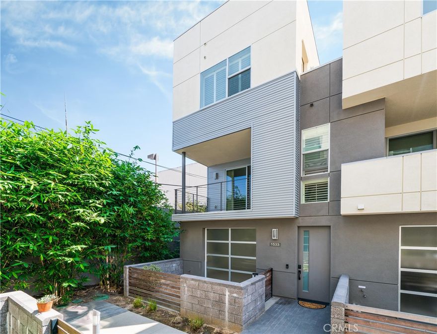 This stunning contemporary three-level townhome is ideally located and thoughtfully designed for modern living. Featuring a private rooftop deck with sweeping panoramic views, a versatile main-level bedroom or workspace, a full bathroom, and a two-car attached garage, this home offers exceptional flexibility and style.  The entry level showcases a unique roll-up door that opens to an enclosed patio, creating an ideal space for a home office, business, gym, or optional third bedroom, complete with a full bathroom and walk-in shower.  The second level features a spacious, light-filled great room that flows seamlessly to an outdoor patio and a gourmet kitchen appointed with elegant stone countertops, crisp white cabinetry, stainless steel appliances, a butler’s pantry, and a convenient guest bathroom.  On the third level, the primary suite offers a serene retreat with a beautifully upgraded bathroom and walk-in closet, alongside a secondary bedroom, an additional full bathroom, and an in-closet stackable washer and dryer. This level also provides access to the private rooftop deck, perfect for entertaining or relaxing while enjoying stunning views.  Ideally situated near the Newport Beach coastline, world-class beaches, premier dining and shopping, top-rated schools, major freeways, and John Wayne Airport, this exceptional home delivers the best of coastal Southern California living.