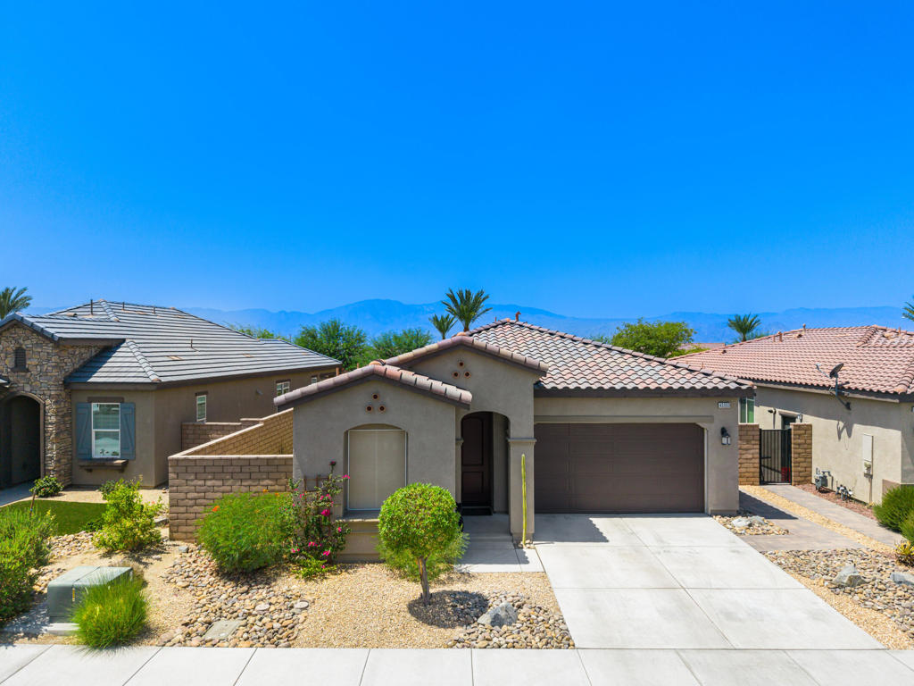 Welcome to 43553 Treviso Drive -- a beautifully upgraded home in the heart of Indio that perfectly blends comfort, efficiency, and style. This open-concept floor plan features 2 spacious bedrooms, 2 bathrooms, and a versatile den that can serve as a home office or guest space. A unique 2-car garage plus a dedicated golf cart bay provides ample room for vehicles and desert toys alike.Step inside to discover brand new designer tile flooring throughout, adding a fresh, modern feel to an already move-in ready home. The living areas are accentuated by soaring ceilings, custom window treatments, recessed lighting, and upscale fixtures and fans. The kitchen is a true centerpiece, offering granite countertops, high-quality white cabinetry with updated pulls, stainless steel appliances, and a stool-height island with stylish pendant lighting that opens seamlessly to the dining area and great room with direct patio access.The king-sized primary suite is bathed in natural light from three large windows and includes a generous walk-in closet. The en-suite bath is appointed with dual vanities, a glass-enclosed step-in shower, and newly updated toilets and faucet hardware for a fresh, refined touch.Additional features include a finished laundry room with cabinet storage, deep utility sink, and washer/dryer, plus a tankless water heater for on-demand hot water and energy savings.Step outside to a covered patio expanded with elegant pavers--perfect for outdoor lounging or entertaining. There's ample space to add a spa or waterfall feature to create your private desert oasis.