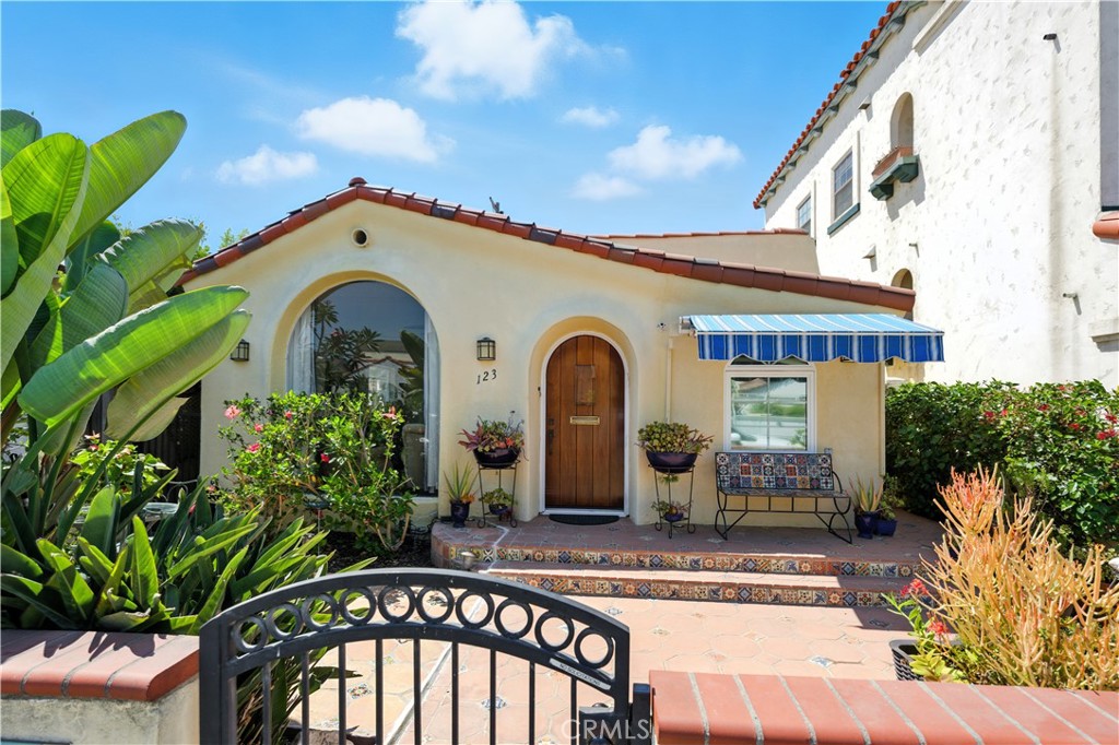 Just Steps to the Sand and 2nd Street – Classic Spanish Charm in the Heart of Belmont Shore..This beautifully preserved 2-bedroom, 2-bath Spanish bungalow is ideally located just steps from Alamitos Bay and beach and the vibrant shops and restaurants of 2nd Street. Rich in original character and thoughtfully updated, the home welcomes you with a spacious brick patio—perfect for morning coffee or greeting neighbors as they stroll by..Step inside to a light-filled living room featuring elegant arches, coved ceilings, a dramatic floor-to-ceiling picture window, and stunning restored hardwood floors. The adjacent dining area, complete with built-in desks and tray ceiling with crown molding, flows into a generously sized kitchen offering abundant cabinetry, a brand-new range, and a charming breakfast nook framed by an arched window that overlooks the private backyard oasis. Out back, enjoy a secluded entertainer’s patio with a built-in BBQ and bar, dedicated dining and lounging areas, and even an outdoor shower—ideal after a day at the beach. The primary suite includes a stylish barn door leading to a remodeled three-quarter bath. The second bedroom features a full wall of built-ins, perfect for a guest room or home office. A beautifully maintained original hall bath offers comfort and charm for guests.. Additional features include: Original hardwood floors throughout, custom crown molding and ceiling details, arched architectural accents, detached one-car garage with laundry hookups, additional parking space. Live the Belmont Shore lifestyle with the beach, bay, bike path, Rosie's Dog Beach, and all the watersport activities just moments away!