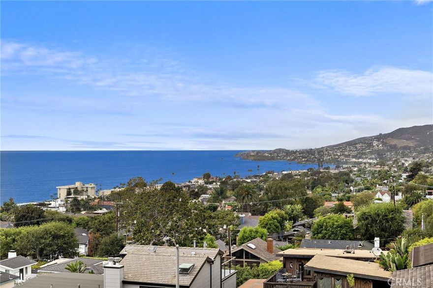 Perched above the coastline in the coveted Woods Cove neighborhood, this contemporary residence captures sweeping ocean, Catalina, and coastline views from nearly every room. Designed with an emphasis on light and scenery, the home features expansive picture windows, multiple view decks, and a seamless indoor-outdoor flow. The main living area is filled with natural light and opens to a generous balcony, creating the perfect setting for sunset entertaining. The kitchen is appointed with warm wood cabinetry, granite counters, stainless steel appliances, and a butcher-block island with cooktop. Multiple outdoor spaces, including a terraced hillside garden and a private rear patio with stone walls, provide tranquil retreats surrounded by nature.  Upstairs, the primary suite offers panoramic views and a bath with dual vanities, soaking tub, and separate shower. Additional bedrooms are well sized and versatile, ideal for guests or a home office.  With two single car garages, off-street parking, and proximity to Laguna’s beaches, shops, galleries, and dining, this property presents an exceptional opportunity to enjoy the best of coastal living in one of the city’s most desirable enclaves.