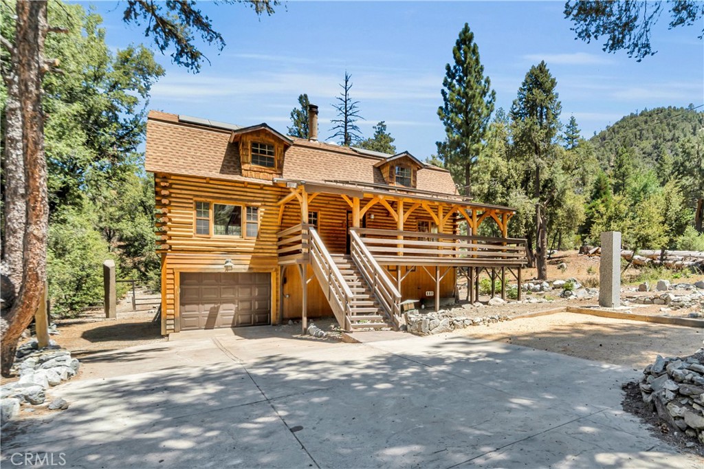 Experience the beauty of mountain living in this inviting log home located in Pine Mountain Club. This spacious property offers 3 bedrooms, 2.5 bathrooms, and a loft area, along with a separate living room featuring a cozy fireplace adjacent to the dining area. The kitchen is designed with granite countertops, rustic wood cabinetry, and windows framing scenic mountain views.
A second living area includes its own fireplace, a built-in bar, and access to a private deck surrounded by trees—perfect for outdoor relaxation. Additional features include a laundry room, an attached garage, and a versatile bonus space adjacent to the garage. The covered front porch offers another great spot to enjoy the fresh mountain air.
Residents of Pine Mountain Club enjoy a variety of community amenities and the convenience of being approximately one hour from the nearest larger city. This property blends comfort, character, and natural beauty—an excellent opportunity to own in this fantastic mountain community.