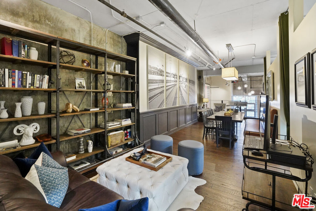 Nadia Geller Designs has created the interior of this breathtaking 2-story Barker Block live/work loft being offered fully furnished. All contents, including furniture, fixtures, kitchenware, carpets and motorized window treatments, plus a custom-built wardrobe, showcase the classic Nadia Geller signature style known as "casual luxury." The loft is structured with the residence on the ground floor. It features 20' ceilings in the living room, a dining area, gourmet kitchen with island, bar area, bedroom and full bath; on the second floor, you'll find a work space comprising three offices, a conference area, a lounge area, storage space and full bath. There is direct access from the second floor hallway. This live/work home is perfect for the next business owner looking for a turnkey space. Or, if your Buyer doesn't require an established work space, simply remove the partitions and create that second bedroom, media space or whatever is needed. The West-facing entrance features floor-to-ceiling, dual pane windows; there are sections of polished concrete and hardwood floors; an in-unit washer and dryer; and the loft has direct access from both Hewitt St. and two interior hallways. Your Buyer will enjoy close proximity to the two covered parking spaces, community mailroom, building security and elevator to the resort-style rooftop deck which offers a heated pool & spa, cabanas, BBQs, fire pits, dining areas and a newly equipped fitness center. There is also an inviting courtyard lounge with firepit and seating areas on the ground floor. For residents using amenities who wish to go online there is free common area WiFi. There is 24/7 building security with added safety cameras throughout the building. Located just steps from Urth Caffe & the LA Cleantech Incubator. Central to all Fwys. Near USC; walk to SCI Arc and the new 1st St. Metro station. Revisit the ever-red-hot Arts District, home to Spotify, Warner Bros. Music, SOHO House, award winning 5 star restaurants like Girl and the Goat & Bavel, clubs, taverns & all things hip and trending. You really must see this unique property in person to appreciate all it has to offer.