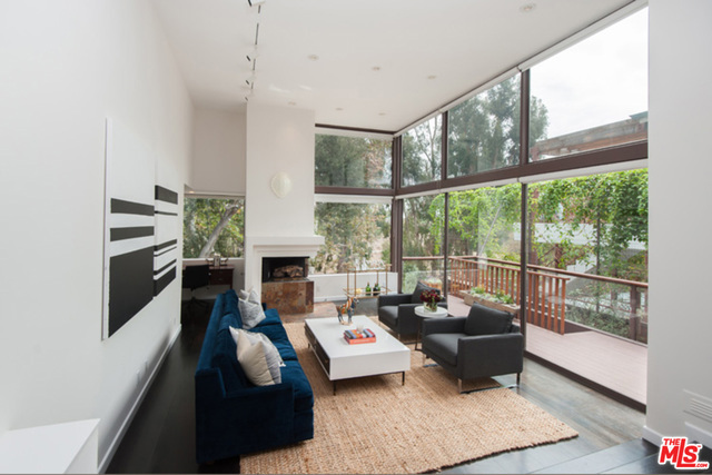 Move right in to this cool custom architectural contemporary close to the Village. Walls of glass and soaring ceilings invite views across the tree tops to the canyon and beyond. Romantic fireplace, hardwood floors and expansive art worthy walls provide the perfect setting for a chic sophisticated loft lifestyle in the heart of Pacific Palisades. Dramatic entry, dining and living room create a great seamless public space perfect for entertaining or quiet time at home. A small nook with a canyon view invites the dreamer in us all. The massive master bedroom with its custom clothes horse closet and fabulous bath takes up the whole top floor. Imagine the ocean breeze on your own roof top deck away from it all. Also with an inviting deck and its own separate entrance, the second bedroom, with en suite bath and tons of storage, sits on the lower level. Great for a home office or guest retreat. Grassy fenced yard with gate out to the canyon for hikes and adventures