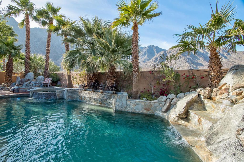 Mountainside Seclusion! With over 4,286 sq. ft. of living space including four bedrooms and three and a half bathrooms. This home features a spacious and inviting entry way that leads into a layout with vaulted ceilings allowing for abundant natural light throughout the interior. The primary bedroom showcases a serene ambiance with scenic mountain views and a spacious private retreat with fireplace. The kitchen boasts ample cabinetry and granite countertops, complementing the overall thoughtful design. Gourment kitchen with six burner stove and grill, a pot filler and mirrored backsplash. The homes lush landscaping creates a tropical oasis, complete with an outdoor patio and outdoor bar area with mood lighting, ideal for entertaining or relaxation. The gated community, provides a low HOA. Enjoy seamless indoor / outdoor living for balance in comfort, style and natural grounding connection. Close to Old Town La Quinta, La Quinta Resort and so much more!