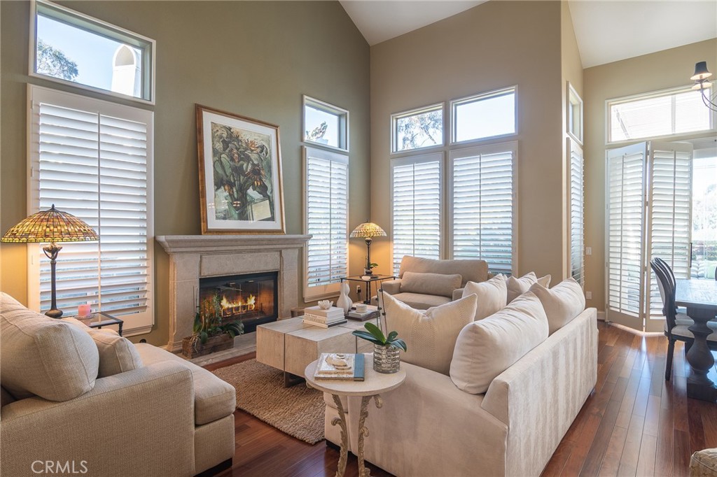 You won't want to miss this beautifully upgraded executive home with gorgeous views! Located in the gated community of Siena, no expense was spared and attention to detail is obvious throughout this beauty. Rich hardwood floors and fossil stone flow throughout most of the living areas. The kitchen features gorgeous custom designer cabinetry, granite counters, and top-of-the-line appliances. A breakfast nook looks out to a private courtyard with fountain. Huge windows and cathedral ceilings flood the home in natural light. The large primary suite features a fireplace and French slider that leads out to a balcony. The primary bath offers a jetted spa tub, beautiful marble shower and double sink vanity. Two additional spacious bedrooms share a jack-n-jill bath, also remodeled. Other features include plantation shutters throughout, ceiling fans in all rooms and updated fixtures throughout. A spacious backyard is a tropical garden with mature but well manicured foliage (including a productive Meyer lemon tree), artificial turf and stone patio, a bubbling fountain and panoramic views of the surrounding hills. Enjoy numerous amenities including the Siena pool and spa as well as the Marina Hills recreation center with pool, tennis, pickle ball, bocce ball, clubhouse and play area.