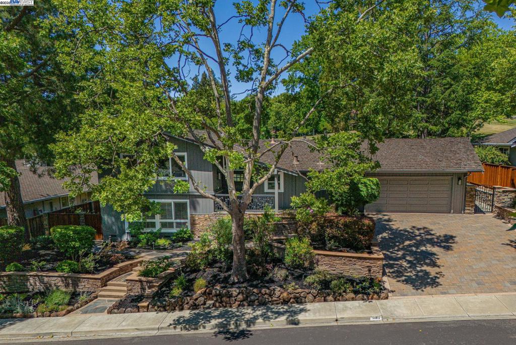 This beautifully appointed Sycamore home offers over 3,000 square feet of refined living space, thoughtfully designed with no detail overlooked. The custom kitchen is a true centerpiece, featuring white granite countertops, an oversized center island, six-burner gas range, built-in refrigerator, and high-end finishes that blend style and function seamlessly. The main living room impresses with vaulted ceilings, custom built-ins, and expansive windows that frame picturesque views of the greenbelt and surrounding hills. Crown molding, inlaid hardwood floors, custom window coverings, and a whole-house audio system are just a few of the elevated details that define this exceptional residence. Step outside and the home truly comes to life. An expansive Ironwood deck with a built-in natural gas fireplace offers the perfect setting for relaxed evenings or vibrant gatherings. The upper deck, accessible from the main living area, extends the entertainment space even further. Below, a covered outdoor kitchen—complete with all the essentials—makes al fresco dining effortless. The professionally landscaped grounds feature custom retaining walls, low-voltage LED lighting, and lush plantings that enhance both curb appeal and outdoor enjoyment. Backing to a peaceful greenbelt, the home provi