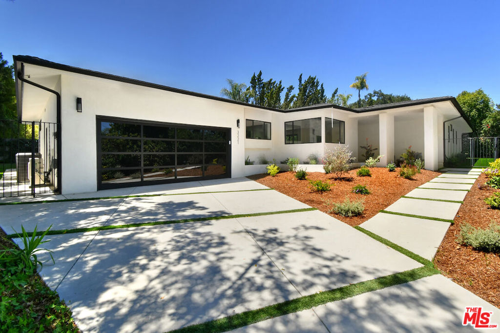 Gated and set back from the street in the Bel Air Skycrest enclave, this single-level modern home sits on a private 16,000 sq. ft. lot with a pool. The light, airy floor plan features hardwood floors and spacious living areas, including a fireplace, a center island kitchen, and a family room with a wet bar. Walls of glass open to a generous yard with a fire pit and multiple patios for entertaining or relaxing by the pool. The formal living and dining rooms overlook lush greenery. A well-planned layout includes three bedrooms grouped together, plus a separate fourth bedroom with an en suite bath ideal for guests or a home office. The large primary suite offers a luxurious bathroom and a custom-designed walk-in closet. Additional features include an indoor laundry room and an attached two-car garage with direct access to the home. Situated along the Mulholland Corridor, the home enjoys access to excellent schools and convenient routes to the Westside.