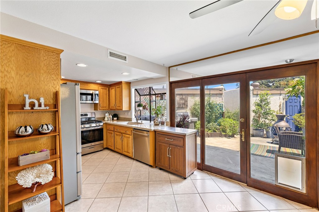 Enjoy the ORANGE lifestyle in this beautifully maintained, pride-of-ownership townhome located in the highly desirable Smoketree community. This clean and spacious two-story unit offers 3 bedrooms and 1.5 bathrooms, with approximately 1,359 sq. ft. of thoughtfully designed living space. The clean and open living area features recessed lighting, ceiling fans, and a whole-house fan for enhanced energy efficiency. The kitchen boasts sleek quartz countertops, a new GE stainless steel gas range, and a Bosch dishwasher, flowing seamlessly into the dining area. Upstairs, the generously sized primary suite includes a walk-in closet and a remodeled, modern bathroom. Two additional bedrooms provide ample space for family or guests. A private fenced patio leads directly to a detached two-car garage with laundry hookups. Additional highlights include dual-pane windows, fresh interior paint, newer A/C (installed just 5 years ago), SPC plank flooring upstairs, and an offset unit placement for added privacy. Ideally situated on the west side of the Smoketree complex—close to the pool, spa, basketball court, clubhouse, additional parking, and open green space in front—this turnkey home offers comfort, style, and an unbeatable location near shopping, dining, parks, and major freeways (91, 55, and 57).
