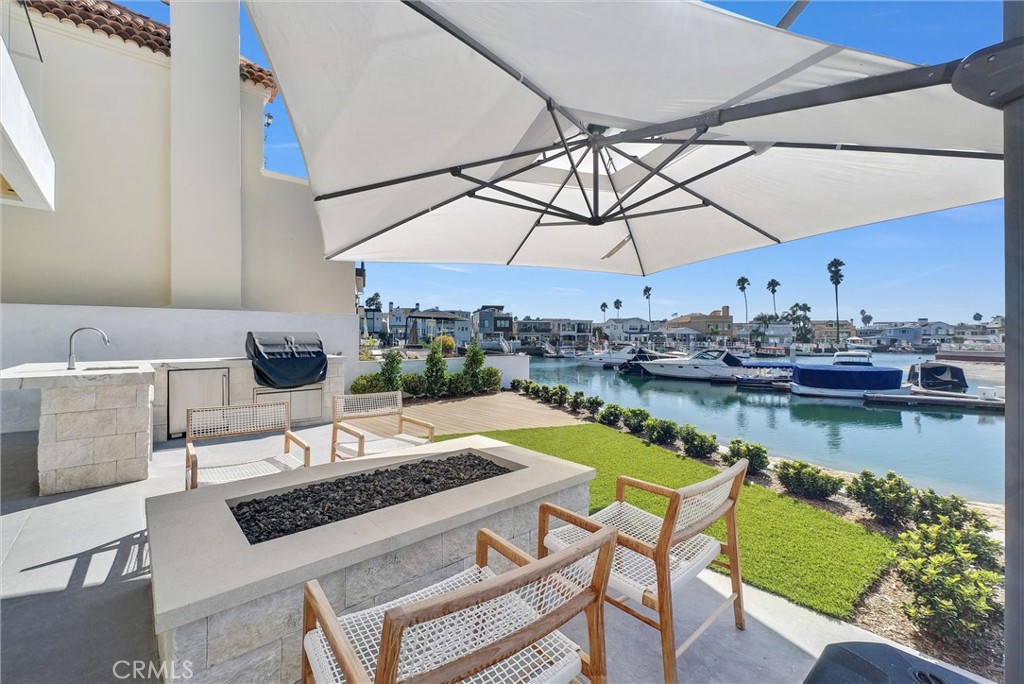 A rare opportunity to own a brand-new, architecturally striking waterfront home in the exclusive gated community of Balboa Coves. Designed by local experts Brian Liberto, architect Craig Hampton, and the renowned teams at MID Design and RDM General Contractors, this modern coastal retreat is a refined example of Newport Beach luxury living.
Situated on an oversized 3,888 sq. ft. lot on the water with a private boat dock, this smart, tech-forward home offers approx. 3,753 sq. ft. of interior living space and over 5,000 sq. ft. total, including garage and outdoor areas. The open layout features 4 bedrooms, 4.5 bathrooms, and a private rooftop retreat with an additional bed and bath — ideal for entertaining or enjoying panoramic Catalina Island and ocean views.
Inside, the home blends modern elegance with coastal warmth, offering European white oak floors, natural stone and tile finishes, tongue-and-groove ceilings, and custom oak detailing. The chef’s kitchen features top-tier Wolf and Sub-Zero appliances, while a temperature-controlled wine cellar holds up to 100 bottles.
Powered by Crestron smart home automation, enjoy fully customizable lighting, climate, audio, and security — luxury at your fingertips.
Step outside to experience the ultimate waterfront lifestyle with your own private boat dock — perfect for paddleboards, Duffy boats, or weekend cruises. The property also includes 4-car parking plus ample guest parking — a valuable bonus in this gated enclave.
Balboa Coves is one of Newport Beach’s most private and coveted waterfront communities, with amenities including a dog park, playground, and peaceful, secure surroundings. You’re just a 5-minute walk or bike ride to Lido Marina Village, the beach, and The Wedge, with nearby access to Fashion Island, restaurants, shops, and freeways.
Whether you're a boater, beach lover, or discerning buyer seeking a coastal dream home, this brand-new construction offers the best in design, lifestyle, and location.
Live the Newport dream — schedule your private tour today.