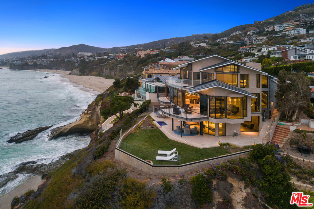 Behind the guarded gates of Three Arch Bay, 56 N La Senda Dr is set on a stunning bluff-top promontory overlooking Thousand Steps Cove. Breathtaking 270 views that look north & south along the coast, showcase the azure Pacific Ocean, crashing waves, private coves, city lights, Catalina Island and unmatched sunsets. The newly constructed residence represents the last home design of legendary architect Mark Singer & the culmination of more than 15 years of design, approvals & construction. Secluded at the end of a long driveway, the contemporary multi-level masterpiece spans 3 levels, each with floor-to-ceiling windows that perfectly frame the homes priceless views. Enjoy 5 bdrm suites and 7 bths in ~ 5,000 sf. An elevator serves all levels, including a lower floor with office, a media room & a terrace w/ spool. The top level hosts a luxurious primary suite that appears upon entry to be floating on the ocean, and the main level showcases a soaring foyer with floating staircase and an open living, dining and kitchen space with two balconies. An enormous island with bar seating anchors the sleek kitchen, which displays quartz countertops with waterfall edges, custom gloss-white and wood cabinetry, and the finest appliances available today.