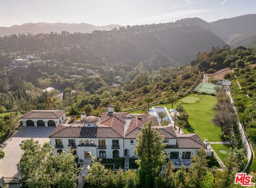 PRICE REDUCTION! $49,500,000. The Westside's most exclusive offering - a rare and exciting opportunity to acquire the only completely redone tennis estate in the ultra-private enclave of Brentwood Country Estates, the guard-gated community of just 13 homes known for its unmatched 24/7 security, privacy and gorgeous views. Gracefully sited on its own five acre promontory, behind its own gates, this truly one of a kind property, completely reimagined and redesigned, is offered fully furnished, ready to welcome you without delay. When you arrive, you are overtaken by a sense of serenity, peace and calm. Taking your first breath of the mountain air, you can feel yourself starting to relax. Where else west of the 405, can you live in your own five star resort and enjoy the low key comforts of home?  A "welcome home" lounge area is the first "Oh wow" moment, leading through the property to the many curated outdoor areas, each providing private spaces for different ways to enjoy the ultimate California lifestyle. The gorgeous pool and spa invite you to luxuriate in the afternoon sunshine. Surrounding the pool, the expansive lawn offers a fun putting and chipping green. Beyond through the olive tree lined walkway is a sunken and lit tennis court, easily converted for pickleball and basketball, with a viewing pavilion complete with its own changing room and bath. The property is beautiful during the day, but in the evening it absolutely glows with gorgeous lighting and music everywhere. The approximately 9960 square foot interior is filled with natural light and stylish sophistication. The sightline of the entry hall previews great things to come, and it does not disappoint. The entry leads to the formal living room and expansive dining room, flanked by a beautiful office all with floor to ceiling windows offering views of the perfectly manicured grounds. The heart of the home is the chef's kitchen with a spacious breakfast area with its own big screen TV,  temperature controlled wine room, and oversized island, with all the best high end appliances, double Wolf range, double side by side Dacor refrigerators, three sinks, and "they thought of everything" butler's pantry.  Right outside the kitchen facing the mountains, through two sets of French doors, the barbecue and outdoor dining areas provide the perfect venue to gather under the stars and watch the moonrise. Adjacent to the kitchen is a fabulous family room, designed for pool, backgammon or just hanging out until dinner is ready.  Motorized  black-out drapes can convert this space for snuggling up on a comfy sectional to watch your favorite movie. The first level also features a large guest suite, and commodious laundry room with double appliances, a mud room and plenty of storage. On the second level, the dreamy primary suite offers a sanctuary with peaceful views to the sky and mountains, reminiscent of your last great trip to Tuscany or Provence. Tons of mirrored closets and built-ins separate the two sides to the bath area, connected by a distinctive wet room double shower and tub. Three additional ensuite bedrooms provide comfort and privacy for guests or family, and a fully equipped gym completes the upper level. The entire home is powered by a state-of-the-art Crestron smart system, offering seamless control of lighting, music, climate and security with cameras everywhere. In addition to the oversized three car garage, the circular motorcourt is large enough to accommodate ten cars. Located in lower Mandeville Canyon, Brentwood Country Estates, provides easy access to Santa Monica, and other areas of the Westside, with wonderful restaurants, shops, hiking trails, golf and the beach minutes away.