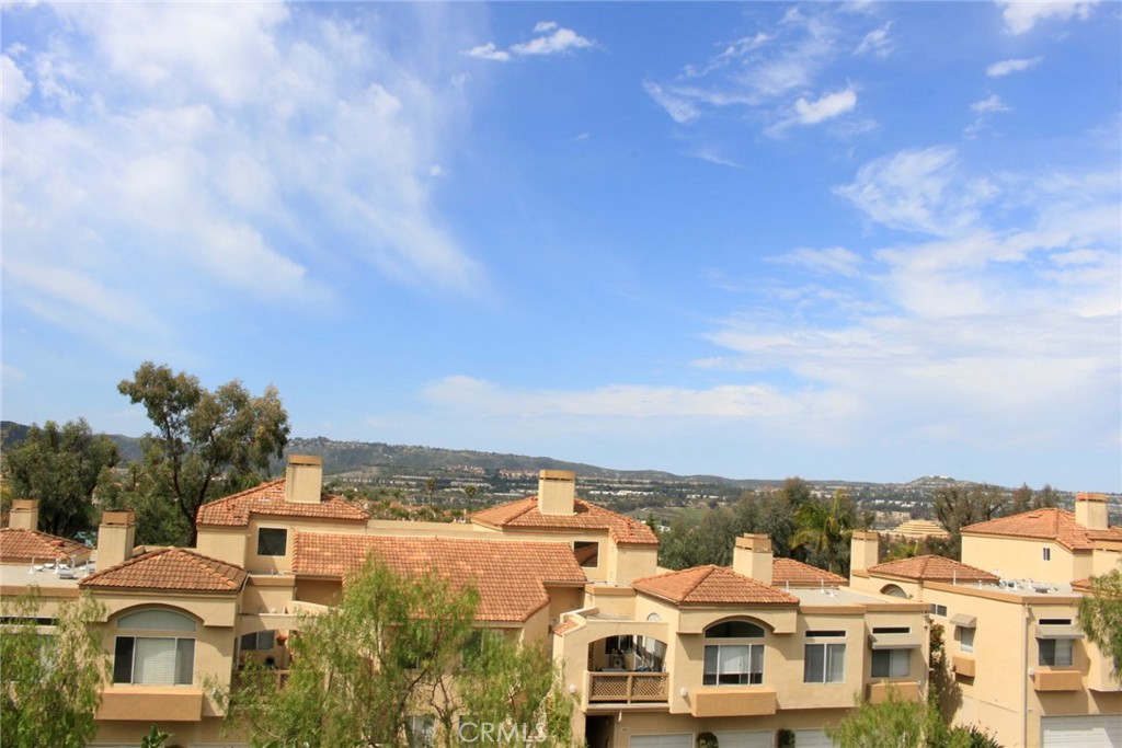 Great panoramic views, enjoy unobstructed sunset or city light views from this Rancho Niguel townhome. On the main floor you will find an open living room with a fireplace, and dining room with a walk out patio that overlooks the city of Laguna Niguel. Tall vaulted ceilings with oversized transom windows that bring in lots of light. The kitchen is finished with Granite counters, new Stove, Microwave and Dishwasher, travertine floors and a large window to enjoy the views. First floor also includes a spacious en-suite master bedroom and a 2nd room that can be a home office or bedroom. On the top floor there is a 3rd bedroom and bathroom with a stall shower. Finishes include rich cherry laminate flooring throughout. The master suite has a large walk in closet and a long dual vanity coutner with 2 mirrors. Central Air Conditioning and Heat. Freshly painted, added recessed lighting, turn key and ready for you. Inside private laundry room, direct access attached garage and assigned parkign stall. Enjoy living in the Rancho Niguel part of Laguna Niguel. Nearby are great trails, parks, close to the beach and Dana Point Harbor. Community pool.
