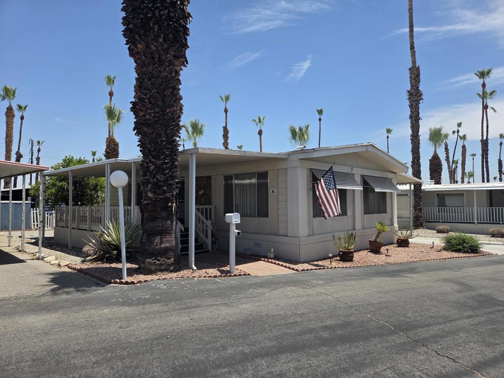 Located in the Royal Palms 55+ community, 257 Wolf, a 1973 Golden West 1440 sq. ft., two bedroom / 1 3/4 bath mobile home, defines gracious, traditional desert living. A large north-facing deck with dark green carpeting welcomes visitors; the home's front door opens into an expansive formal living room, adorned with lush draperies, offering two spaces for entertaining as well as a handsome built-in desk / office area. The crisp elegance extends to the dining area which opens into the spacious kitchen with white appliances and extensive cabinetry; beyond is the laundry room with side-by-side W/D and extensive storage. Down a short hallway, on the left, is the full guest bathroom with wide vanity and a striking glass tub enclosure; opposite is the large and bright guest bedroom replete with walk-in closet and built-in storage. At the east end of the home is the spacious primary bedroom, also with a large walk-in closet with built-in storage; the ensuite 3/4 primary bathroom has an expansive double-sink vanity, a large shower and built-in storage. This lovely residence has central AC/heat and an evaporative cooler. Beautiful cream-colored carpeting extends throughout the home save the two bathrooms, the laundry room and the kitchen, all of which have matching, tasteful laminate flooring. Tandem parking is under a carport awning on the south side of the home; there is a large shed on the premises as well. 257 Wolf is sold with the many lovely pieces of furniture and all furnishings that remain in the home. Approval by park management at the Royal Palms is required for purchase; monthly space rent for this home will be $852.00 per month for the new owner, though that figure must be verified by buyer.