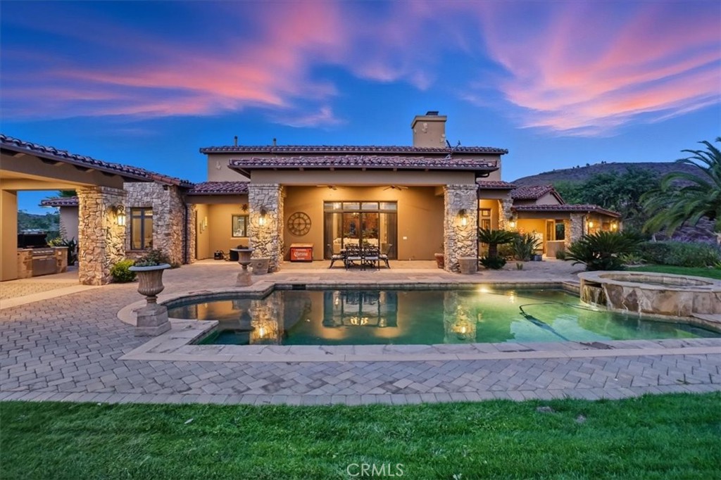 Nestled within the exclusive Oakridge Ranch Estates, this extraordinary 15.6-acre property perfectly combines refined country living with modern luxury. Designed for comfort and sophistication, it offers a rare balance of elegance, privacy, and functionality. Surrounded by scenic horse trails, the estate features extensive equestrian facilities and income-producing opportunities, making it ideal for horse enthusiasts or investors seeking a serene ranch setting.
The main residence offers 3 spacious bedrooms and 3.5 bathrooms, while a detached guest house provides 1 bedroom and 1 bathroom, perfect for extended family or guests. Inside there are vaulted ceilings, chandeliers, and exquisite tile flooring for a luxurious living. This home is equipped with smart home technology that allows full control of lighting, climate, and security from anywhere in the world with aHomeWorks lighting system & three-zone HVAC.
The living room is inviting with a beautiful stone fireplace and built-in mini bar, perfect for entertaining. The gourmet kitchen is a chef’s dream, complete with a walk-in pantry, double oven, center island with built-in refrigerator, and premium Wolf cooktop. Adjacent, the dining area is filled with natural light and offers breathtaking views of the property.
The primary suite is a true retreat, with its own fireplace, a luxurious bathroom with walk-in shower, tub, vanity area, and expansive walk-in closet that has its own washer and dryer.
Step outside to a private paradise: a resort-style backyard with a sparkling pool and spa, built-in BBQ, outdoor shower, mounted TV, and a spacious covered patio, ideal for relaxing or entertaining.
The equestrian facilities are a standout feature and currently generate income. These include a 20+ stall show barn with office, 18-stall mare motel, a large fenced performance arena, and multiple fenced pastures—all designed for efficient, easy operation. Supporting infrastructure includes an Artesian well, a commercial-grade reverse osmosis water system producing up to 2,800 gallons per day, an oversized propane tank, and commercial traffic-rated septic systems for both homes. The reinforced concrete driveway is engineered to support the weight of an 18-wheeler, and a lease-free solar system adds long-term energy efficiency.
More than just a home, this Oakridge Ranch Estates property offers a lifestyle with luxurious amenities, income, and the serenity of ranch living.