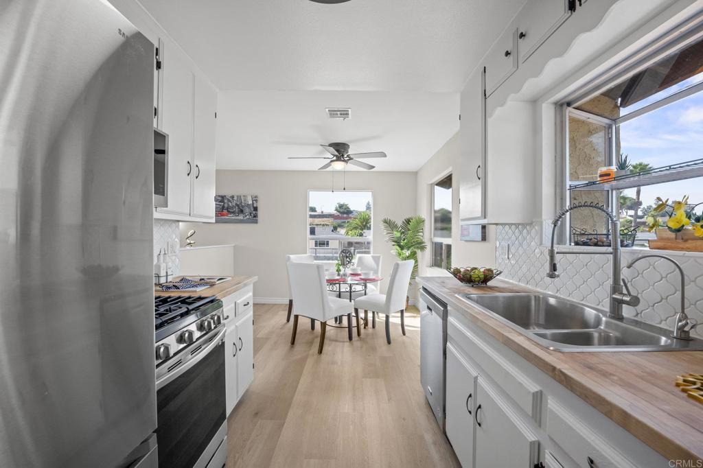 Lemon Grove is know for having the “Best Climate on Earth.” Only 12 miles to Downtown and 10 miles to the airport! Spacious and thoughtfully upgraded, this home sits on a large .32 acre lot at the end of a peaceful street with no through traffic. Step inside to the first living area, where light wood laminate flooring, large windows, and shiplap accent walls create a bright, airy atmosphere. The space flows seamlessly into the dining area and freshly painted galley-style kitchen, with crisp white cabinetry, a charming tile backsplash, butcher block countertops, and a box window that perfectly frames views of the Coronado Bridge on clear days. The refreshing breeze from Coronado drifts through the home, naturally keeping it cool and comfortable. Downstairs, a second living space offers a cozy retreat with a fireplace and a slider that opens to the expansive patio and backyard. This outdoor space is full of possibility—host movie nights under the stars, create a lush garden, or even add a pool. With the entire fence replaced in 2025, it’s a private and secure setting with sweeping neighborhood views. All bedrooms are thoughtfully located on the lower level. The primary suite features a walk-in closet and a beautifully remodeled ensuite bathroom, completed in December 2024 with modern touches like a heated towel rack, LED fog-clearing mirror, mosaic stone tile flooring, and a walk-in shower. Secondary bedrooms are nicely sized and share an updated guest bathroom, while the laundry room sits conveniently nearby. Additional updates include ceiling fans throughout, fresh interior paint, popcorn ceiling removal, new carpet, a newer sewage pump, and a brand-new roof. With friendly neighbors, nearby parks, schools, shopping, and easy freeway access, this home offers both comfort and convenience in a serene setting. Welcome Home!