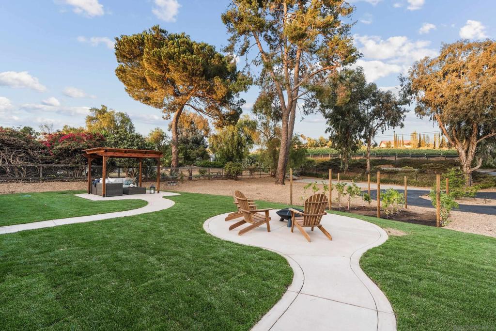 ASK ABOUT THE SELLER'S RATE BUY DOWN - Available for qualified buyers to secure a reduced interest rate! Your serene retreat in the rolling hills of Escondido awaits! Set on just over half an acre across from Hungry Hawk Winery, this single-story 4-bedroom, 2.5-bath home offers the comfort of single-level living with open spaces designed for connection and relaxation. The dual-sided fireplace warms both the living and family rooms, while the spacious primary suite provides a private escape—now featuring a beautifully remodeled bathroom. Step outside to enjoy gentle breezes from the covered patio, gather around the firepit, or take in the vineyard views from the fully finished front yard. The wrap-around driveway, RV parking, and abundant guest space offer unmatched convenience. Backyard has room for a pool! With a peaceful setting just minutes from the San Diego Safari Park and city conveniences, this home delivers the perfect blend of privacy, comfort, and accessibility.