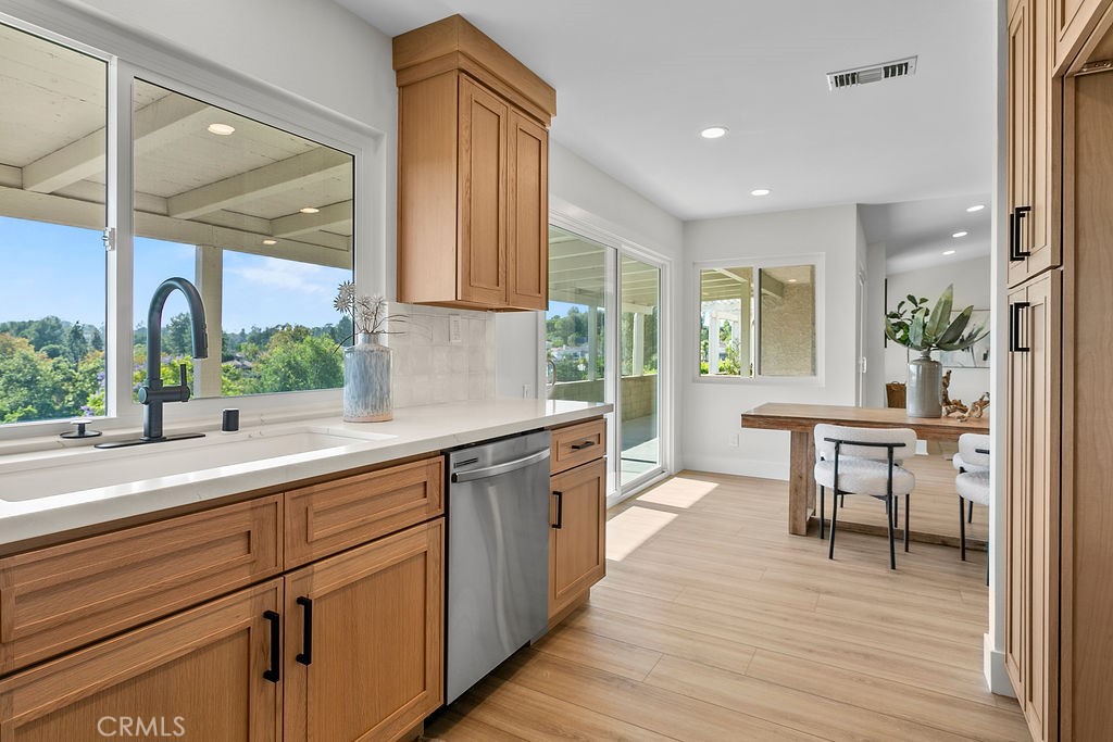 Casta Del Sol is all about the location and this house delivers! One of the best with incredible panoramic views from inside and out of the blue skies, treetops, and golf course below. This 2 bedroom, 2 bathroom renovated home sits in a great location near the end of the cul de sac. All new dual pane windows and sliders, renovated white oak kitchen with quartz counters, stainless steel appliances and stylish tile backsplash complete the designer style. Both bathrooms have also been updated with new cabinets, tile, and light fixtures. The living room features vaulted ceilings, recessed lights and a fireplace. Light colored luxury vinyl plank flooring and vaulted ceilings make the living space welcoming to friends and family. The private space behind this home gives maximum privacy and sunlight. Enjoy access to Lake Mission Viejo and the Casta Del Sol HOA that includes clubs sports, pickleball, tennis, swimming, shuffle board, athletic club, relaxing and so much more!