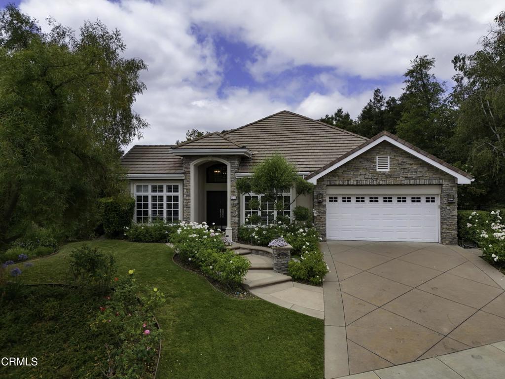 Tucked away in the prestigious Meadows at Sherwood, this stunning Country French-style residence sits proudly on an elevated corner lot, offering exceptional privacy and curb appeal. Meticulously renovated with thoughtful designer touches, the home welcomes you with an impressive entry portico, featuring double doors and an elegant transom window.Designed primarily for single-level living, the home also boasts a spacious loft upstairs--perfect as a media room, home office, or cozy library. Soaring ceilings and expansive windows flood the interior with natural light, creating an airy, open ambiance throughout. The impressive Great Room showcases dramatic two-story beamed ceilings and oversized sliding doors that seamlessly connect to the outdoor dining patio.The open-concept layout flows effortlessly from the gourmet kitchen to the breakfast nook and formal dining area, ideal for both everyday living and entertaining. The luxurious primary suite is a peaceful retreat, with serene views of the landscaped garden and resort-style pool. It includes a generous walk-in closet and spa-like bathroom with a slipper tub, dual vanities, and a private water closet.Two additional bedrooms are thoughtfully placed near the front of the home for added privacy. Outside, the Pebble-Tec pool and spa are accented with natural Bouquet Canyon stone and a cascading waterfall feature. A built-in BBQ station with slate tile counters and bar seating enhances the outdoor living experience, while mature oaks, birch trees, and lush greenery create a picturesque and tranquil backdrop.