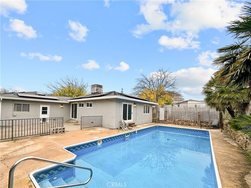 PAID OFF SOLAR!!!  This inviting Oroville home with paid-off solar is ideal for family living, offering 4 bedrooms, 2 bathrooms, and approximately 1,300 sq ft of well designed living space. Situated on a spacious corner lot, the backyard is perfect for entertaining with a large in-ground pool, which is ideal for summer gatherings, barbecues, and making lasting family memories. Inside, the large living room offers a warm, welcoming atmosphere with a cozy wood-burning stove, while all bedrooms are comfortably sized. The oversized primary suite features a recently updated bathroom with a walk-in shower, creating a private retreat.  This home also comes with a fenced-in area for recreational parking, such as a travel trailer, boat, or RV. This home is located in a very desirable area that is close to multiple schools.