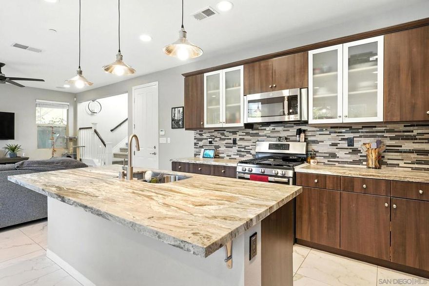 Welcome to 1035 Sea Glass Way, one of only three model homes in this highly sought-after community, fully loaded with exceptional upgrades and premium finishes throughout. This stunning residence features beautiful custom cabinetry paired with top-of-the-line GE appliances, including a double oven, perfect for the home chef. Enjoy elegant granite countertops in the kitchen and bathrooms, marble-like tile flooring, and warm wood flooring in the master suite.The home is equipped with a built-in speaker system throughout for seamless entertainment, blackout shades in the master bedroom, and a luxurious waterfall shower head. The master closet boasts custom shelving, providing ample and organized storage. Thoughtful lighting accents the staircase, enhancing the home's ambiance.  Additional highlights include a low HOA, extremely affordable solar lease, and a spacious two-car garage. Set in a well-maintained community, this home offers both style and comfort with modern convenience. Don’t miss this rare opportunity to own a beautifully upgraded model home in a prime San Diego location!