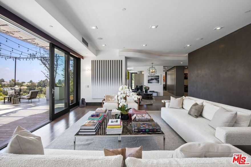 Flawlessly imagined and created by world-renowned architect/developer Ardie Tavangarian of Arya Group. This warm contemporary architectural marvel is set in the tranquil, rolling hills of the Pacific Palisades Riviera with sweeping views of the Brentwood Hills out to the Getty Center, just minutes away from world-class shopping, dining and entertainment in Brentwood, Santa Monica & the Palisades Village. A luxurious, private retreat in a forested setting behind lush trees and gates that evoke peace and serenity with its clean, sophisticated design, soothing palettes, and the finest organic finishes such as rare French limestones and teak wood floors throughout. A magnificent 5-bed, 7-bath, estate with stunning entertaining possibilities encompassing perfectly proportioned infinity pool & spa, oversized lawn with lush landscaping and generous entertainment deck space. Open, sun-splashed living spaces feature a large great room leading to an oversized terrace with a fire pit overlooking the canyon, as well as an open kitchen, family room, den, formal dining room, screening room, master office and staff office. Experience luxurious, sophisticated California indoor-outdoor living at its finest in one of the most coveted neighborhoods in Pacific Palisades.