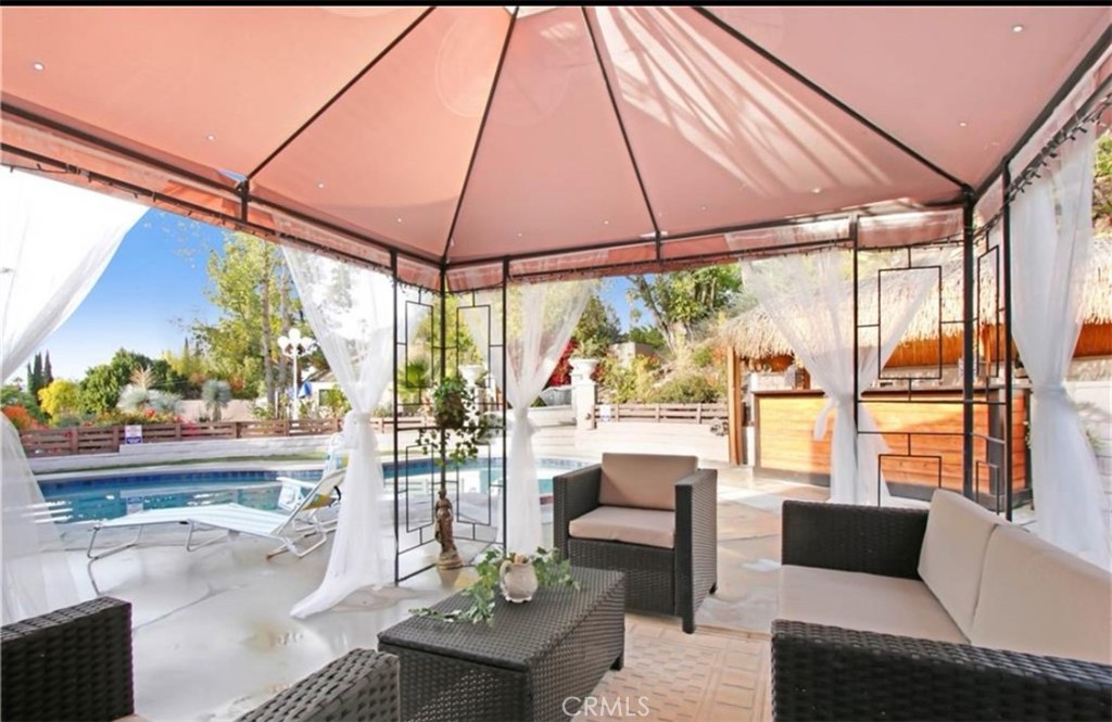 Fully furnished beautifully updated corner-lot home is located on a quiet cul-de-sac in the highly desirable Carlton Terrace neighborhood, just steps from The Topnga Village, Ventura Blvd, Warner Center, restaurants, bars, and major shopping destinations.
Sitting on nearly half an acre, this serene and private residence offers 2 bedrooms, 3 bathrooms, and a versatile den furnished with a queen bed which can be used for an office as well. The open-concept layout connects the living and dining areas to an expansive backyard through oversized sliding glass doors, creating a seamless indoor-outdoor flow.
Enjoy resort-style outdoor living with a brand-new heated pebble pool and spa, Tiki bar, fire-pit, and sweeping sunset views. Every room in the house offers scenic vistas/whether of the lush backyard, pool, hills, or surrounding mountains.
Lease includes WiFi. Available fully furnished for long/short terms stays.
There are 2 guest houses on the premises, please read the remarks and disclosures.