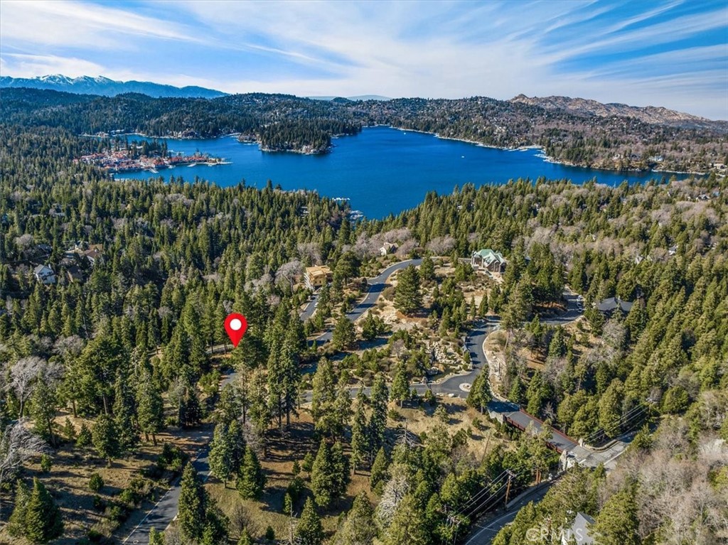 Panoramic lake views meet unmatched privacy and design freedom. Located just 5 minutes from Lake Arrowhead's south shore, this vacant parcel offers sweeping vistas of the lake, extending all the way to Mt. Baldy. The property includes coveted lake rights for exclusive access to private Lake Arrowhead, as well as plans for an over 5,000 sq ft residence. Set within the prestigious Mill Pond gated community, this area is known for its scenic beauty and secure, serene atmosphere. Underground utilities preserve the pristine landscape in Mill Pond, while paved and maintained roads ensure easy year-round access. Surrounded by trees and immersed in four seasons of natural splendor, this parcel is an ideal canvas for your vision.