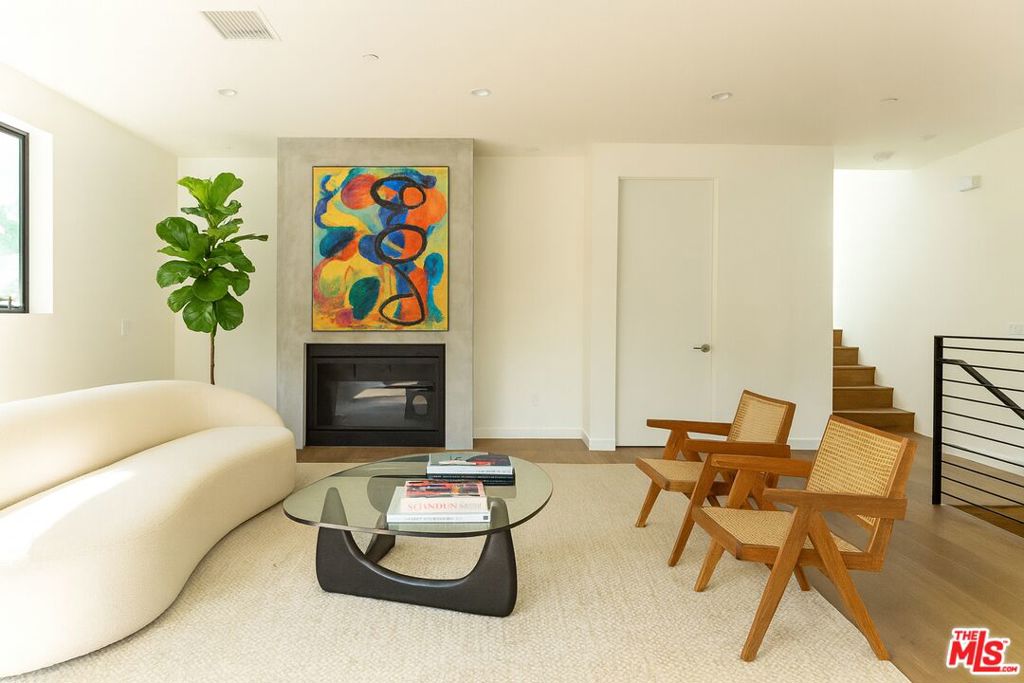 Nestled in the heart of Hollywood Dell, this striking contemporary duplex was designed and built by award-winning developer Giraffe. Sleek, turnkey, and design-forward, the residence offers nearly 1,950 square feet of refined living space with 3 bedrooms and 2.5 bathrooms. The open-concept main level is anchored by a gorgeous chef's kitchen with custom cabinetry, quartz countertops, tasteful lighting fixtures, and premium Samsung stainless-steel appliances. Flow seamlessly into the living and dining areas, complete with high ceilings, recessed lighting, oak wood floors, and a cozy fireplace. A spacious balcony extends the entertaining space outdoors, perfect for morning coffee or evening cocktails. A sculptural staircase leads to the private quarters, with a thoughtful landing featuring a built-in bench. The primary suite feels like a boutique hotel retreat, boasting its own balcony with mountain views, a spa-like ensuite bathroom, and a walk-in closet.Designed for both style and function, the home is surrounded by mature landscaping that creates a serene, California-inspired oasis. Outdoor entertaining spaces, a two-car attached garage, and a laundry room with Samsung washer and dryer complete the offering.Ideally located on a quiet residential street, yet just moments from Hollywood, Los Feliz, Beachwood Canyon, and landmark dining and nightlife. Easy freeway access and proximity to major studios make this home as practical as it is beautiful. A rare opportunity to live in a contemporary jewel in one of Los Angeles' most iconic neighborhoods. The unit is vacant, all images with furniture are virtually staged.