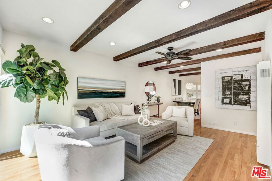 Nestled within a beautifully maintained community, this charming two-story condominium greets you with lush landscaping, mature trees, and vibrant greenery leading to your own private entrance. Step inside and you're welcomed into a sunlit living room, where beamed ceilings and natural light create an inviting sense of warmth and character. Glass doors open to a private patio perfect for savoring morning coffee, hosting friends, or unwinding in the evening with a glass of wine. Just off the living room, the updated kitchen blends style and function with sleek granite countertops, modern stainless steel appliances, and a convenient layout that makes cooking a delight. The adjacent washer and dryer offer everyday ease, so you can catch up on your favorite shows while staying productive on laundry day. Hardwood floors flow seamlessly throughout, adding timeless elegance to the home's thoughtful design. Ideally located just minutes from Playa Vista, Mar Vista, and Santa Monica, with quick access to the freeway, this residence offers the perfect balance of comfort, convenience, and lifestyle. Don't miss your chance to build equity and personalize this home to your taste, all at an exceptional value! AND...if that is not enough, this home qualifies for an absolutely FREE grant up to $20,000 that can be used for closing costs, down payment, or buying down the interest rate.