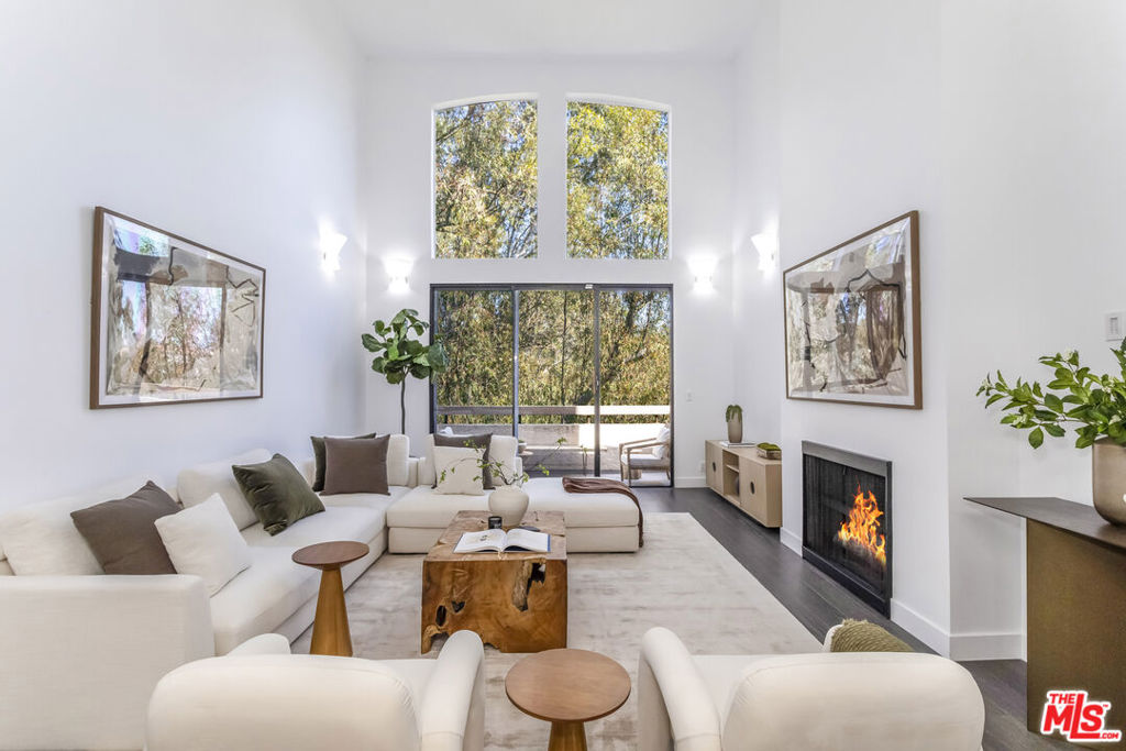 This exceptional penthouse in Brentwood presents a unique opportunity. 410 Barrington features soaring 20-foot ceilings and floor-to-ceiling glass windows, showcasing this meticulously updated three-bedroom residence overlooking a tranquil tree sanctuary. Offering complete privacy, abundant natural light, and uninterrupted treetop views, this property delivers an urban retreat rarely available in Los Angeles. Both the living area and bedrooms benefit from calming vistas of lush foliage, including the serene primary and secondary suites. A custom glass wrap-around staircase leads to a spacious loft, ideal for a home office, recreation, or flexible creative space. An expansive private rooftop terrace offers an unparalleled outdoor setting well-suited for entertaining or enjoying peaceful mornings surrounded by greenery. The modern kitchen, catering to those who enjoy cooking at home, is thoughtfully updated with a breakfast bar. This smart home includes app-controlled security, climate settings, and lighting, supporting effortless and sophisticated living. Owners appreciate building amenities such as front desk security and concierge, swimming pool, jacuzzi, spa, sauna, fitness center, entertainment lounge, conference, two spot parking equipped with 220V outlet, as well as twelve guest parking spots. The location also provides immediate access to a vibrant park with tennis and basketball courts across the street. Situated in Brentwood's premier neighborhood, the residence is steps from San Vicente and downtown Brentwood's renowned cafes, shops, and restaurants, including Alfred Coffee, Whole Foods, and Baltaire Steakhouse. Experience Westside living at its finest in one of Brentwood's most distinguished penthouses.