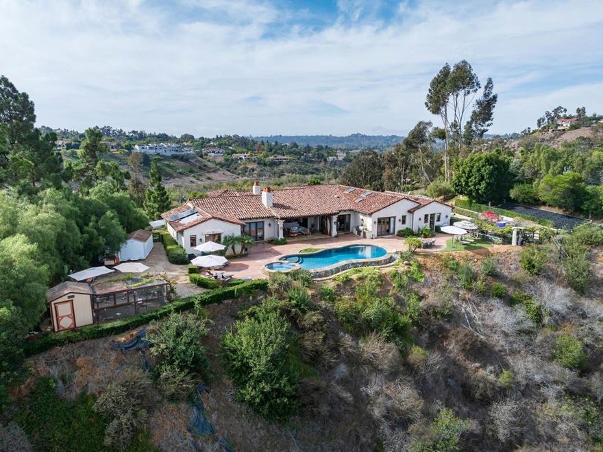 Set on 2.51 elevated view acres in the exclusive Covenant of Rancho Santa Fe, this custom-built 2009 estate has been recently refreshed and showcases 4,523 sq. ft. of beautifully scaled single-level living. Designed for both grand entertaining and everyday enjoyment, the home features soaring ceilings, an open flowing floor plan, and seamless indoor/outdoor living. The great room, with its stone-clad fireplace, lift-and-slide doors, and beverage bar, opens to the chef’s kitchen complete with a sun-filled breakfast area, copper sink, and bar seating. Additional highlights include a formal dining room, artisan-crafted office/library, secondary office, and a powder room. The luxurious primary suite offers a cozy fireplace, spa-inspired bath, and a generous custom-appointed dressing room. Three additional bedroom suites provide comfort for family or guests. Outdoor living is unrivaled, with a magnificent covered living/dining room and fireplace overlooking the resort-style pool and spa, outdoor shower, and expansive lounge areas—perfect for taking in the sweeping, peaceful views. Additional features include: wood and travertine flooring, whole-house and pool solar,  raised-bed vegetable gardens,  extensive chicken coop housing,  gated entry and cul-de-sac location,  garaging for 3 cars. Close to equestrian trails, the RSF Village, Golf and Tennis Clubs, and award-winning Roger Rowe schools, this estate blends elegance, comfort, and convenience in one of Rancho Santa Fe’s most coveted settings.  Set on 2.51 elevated view acres in the exclusive Covenant of Rancho Santa Fe, this custom-built 2009 estate has been recently refreshed and showcases 4,523 sq. ft. of beautifully scaled single-level living. Designed for both grand entertaining and everyday enjoyment, the home features soaring ceilings, an open flowing floor plan, and seamless indoor/outdoor living. The great room, with its stone-clad fireplace, lift-and-slide doors, and beverage bar, opens to the chef’s kitchen complete with a sun-filled breakfast area, copper sink, and bar seating. Additional highlights include a formal dining room, artisan-crafted office/library, secondary office, and a powder room. The luxurious primary suite offers a cozy fireplace, spa-inspired bath, and a generous custom-appointed dressing room. Three additional bedroom suites provide comfort for family or guests. Outdoor living is unrivaled, with a magnificent covered living/dining room and fireplace overlooking the resort-style pool and spa, outdoor shower, and expansive lounge areas—perfect for taking in the sweeping, peaceful views. Additional features include: wood and travertine flooring, whole-house and pool solar,  raised-bed vegetable gardens,  extensive chicken coop housing,  gated entry and cul-de-sac location,  garaging for 3 cars. Close to equestrian trails, the RSF Village, Golf and Tennis Clubs, and award-winning Roger Rowe schools, this estate blends elegance, comfort, and convenience in one of Rancho Santa Fe’s most coveted settings.