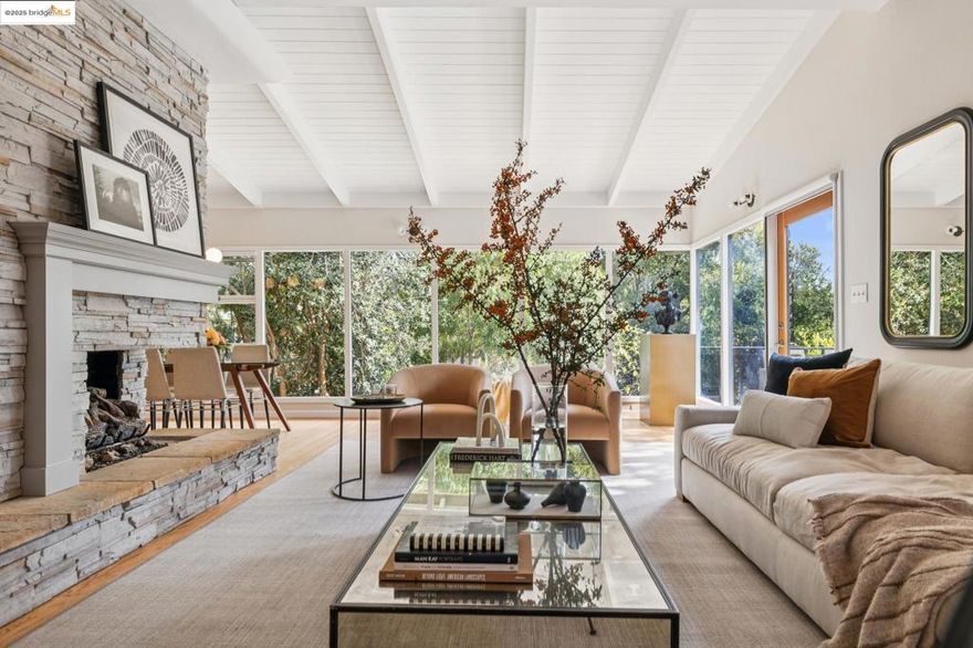 This luminous mid-century modern residence captures the essence of California living. Perched on one of Crocker Highlands’ most desirable streets, 1297 Sunnyhills Road celebrates mid-century architecture with clean lines, walls of glass, and seamless indoor–outdoor flow. A level-in entry with no steps opens to a light-filled main floor featuring an updated kitchen, spacious living and dining areas, and a primary suite on the main level. The two-car garage with interior access adds everyday convenience.  Both upper and lower levels open to expansive Ipe decks for lounging and entertaining among the trees. Downstairs offers two large bedrooms, a full bath, and a second fireplace, creating the perfect space for guests or a family room.  Additional highlights include two-zone central heat, two fireplaces, abundant storage, and a fully fenced, level backyard with lawn. Ideally located near Crocker Highlands Elementary, Lakeshore Avenue, and Lake Merritt’s shops and cafes.