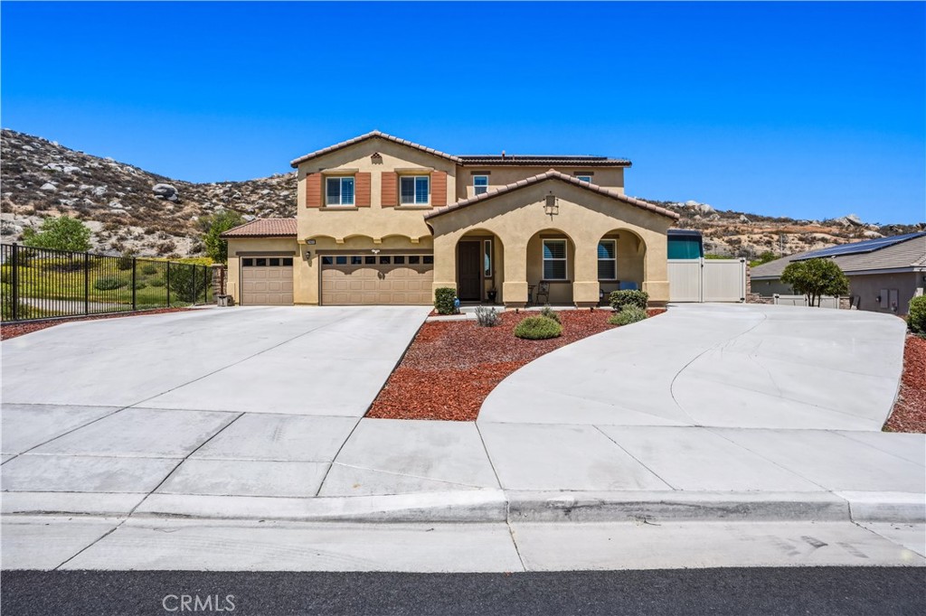 Front elevation with covered front patio to the views, gated RV parking and driveway, three car garage and no one next to home on one side.