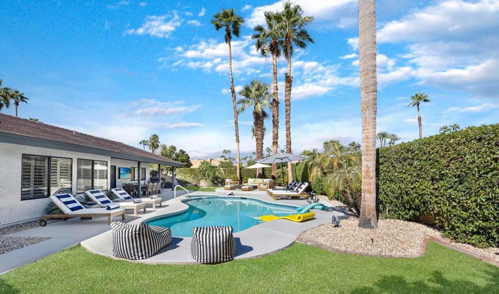 Nestled in the heart of Rancho Mirage, just moments from the iconic Sunnylands estate and Tamarisk Country Club, this luxurious 4-bedroom, 3-bathroom retreat offers the ultimate getaway. Boasting over 2,500 square feet of beautifully designed indoor space and 1,800 square feet of outdoor living, this Mid-Century Modern home exudes style and sophistication.The entry opens to an expansive great room with vaulted ceilings, a cozy fireplace, and views of the lush backyard. The large entertainer's kitchen features a massive center island with casual bar seating, complemented by rare Sandalus Satin granite slabs and Marfil Caesarstone Quartz countertops. The space flows seamlessly into the dining area, with breathtaking views of the pool and surrounding mountains. Stainless-steel appliances and custom cabinetry complete the kitchen's appeal.The oversized private backyard is a true oasis, with a sparkling saltwater pool and spa, offering the perfect balance of sun and shade. Covered and uncovered patio areas, manicured landscaping, and towering palm trees create a serene environment for relaxation.The home features four well-appointed bedrooms, including a master suite with a king-size bed and a spa-like en-suite bath with a walk-in shower and soaking tub. A second master suite offers pool views, and two guest bedrooms boast scenic mountain views. This is the one. Make this your perfect vacation home.